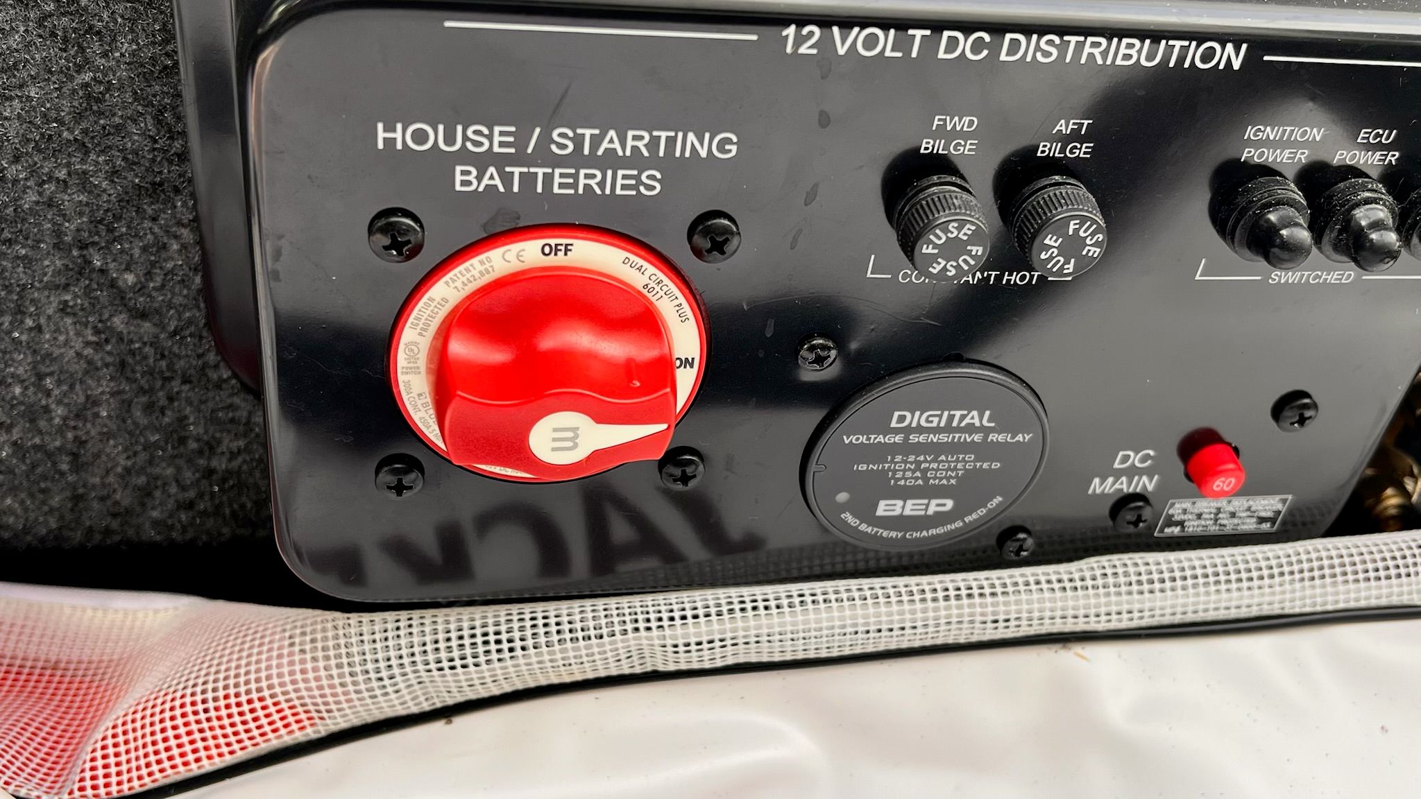 Close-up of a 12-volt DC distribution panel with switches and a battery selector.