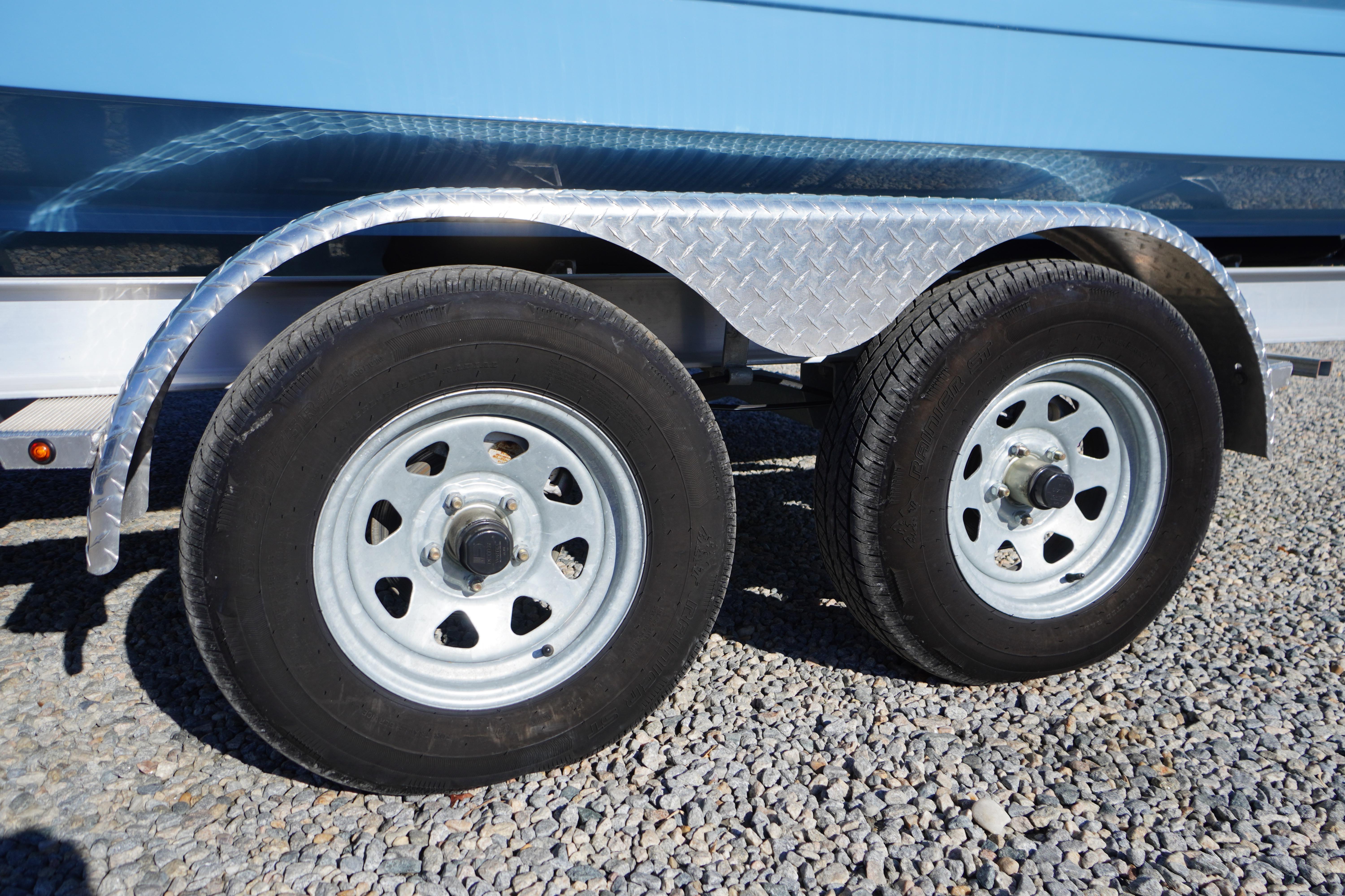 Trailer wheels of 2026 Chaparral 23 SSi boat on gravel surface.