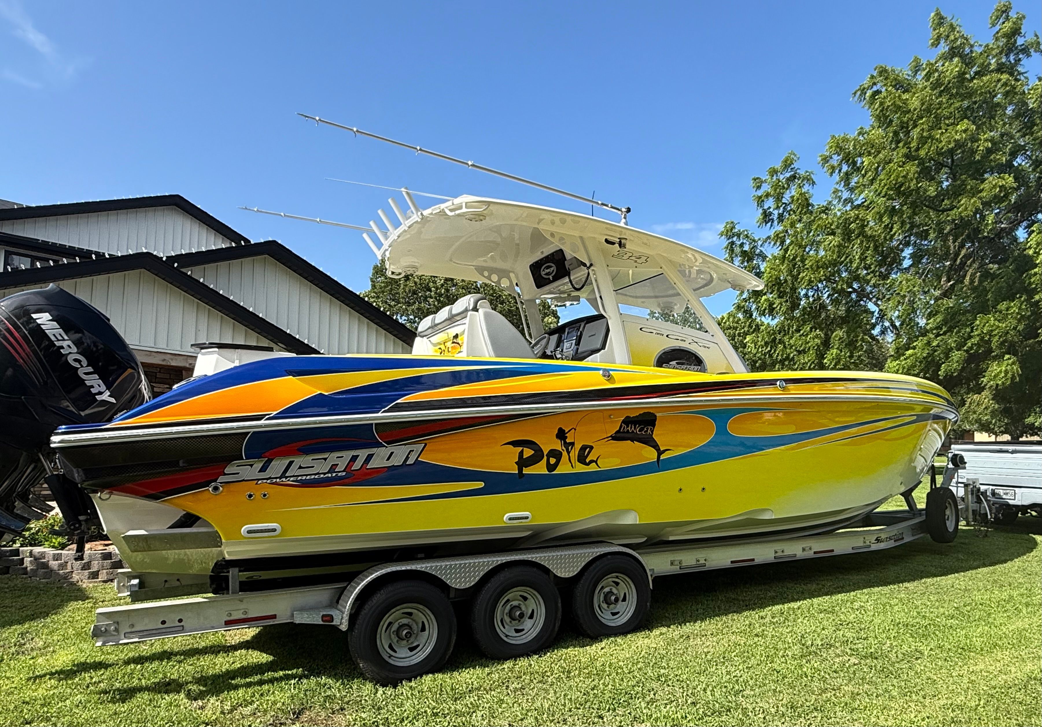 A yellow boat on a trailer with a white roof and colorful graphics.