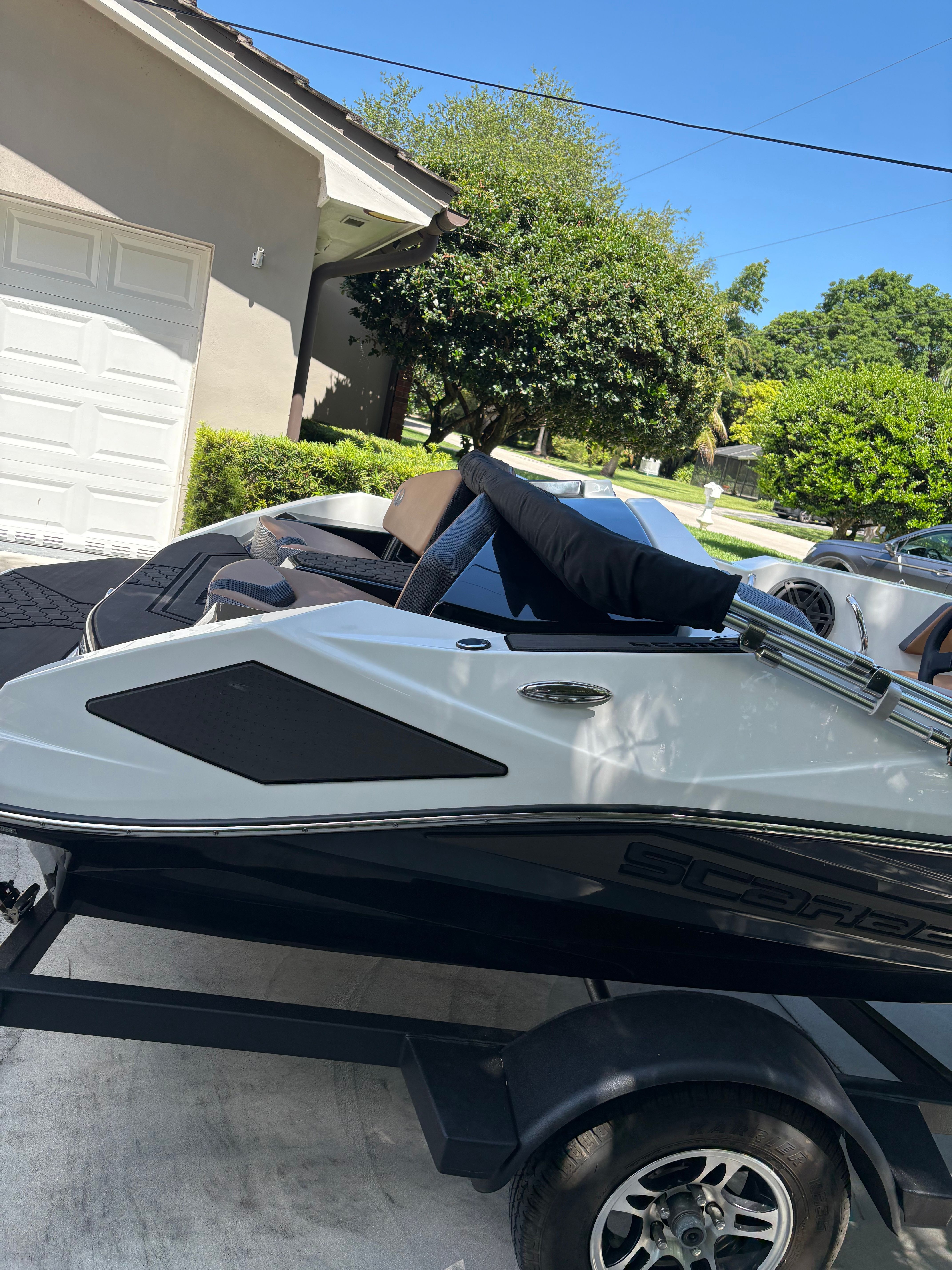 A 2022 Scarab 165 ID boat on a trailer in a driveway.