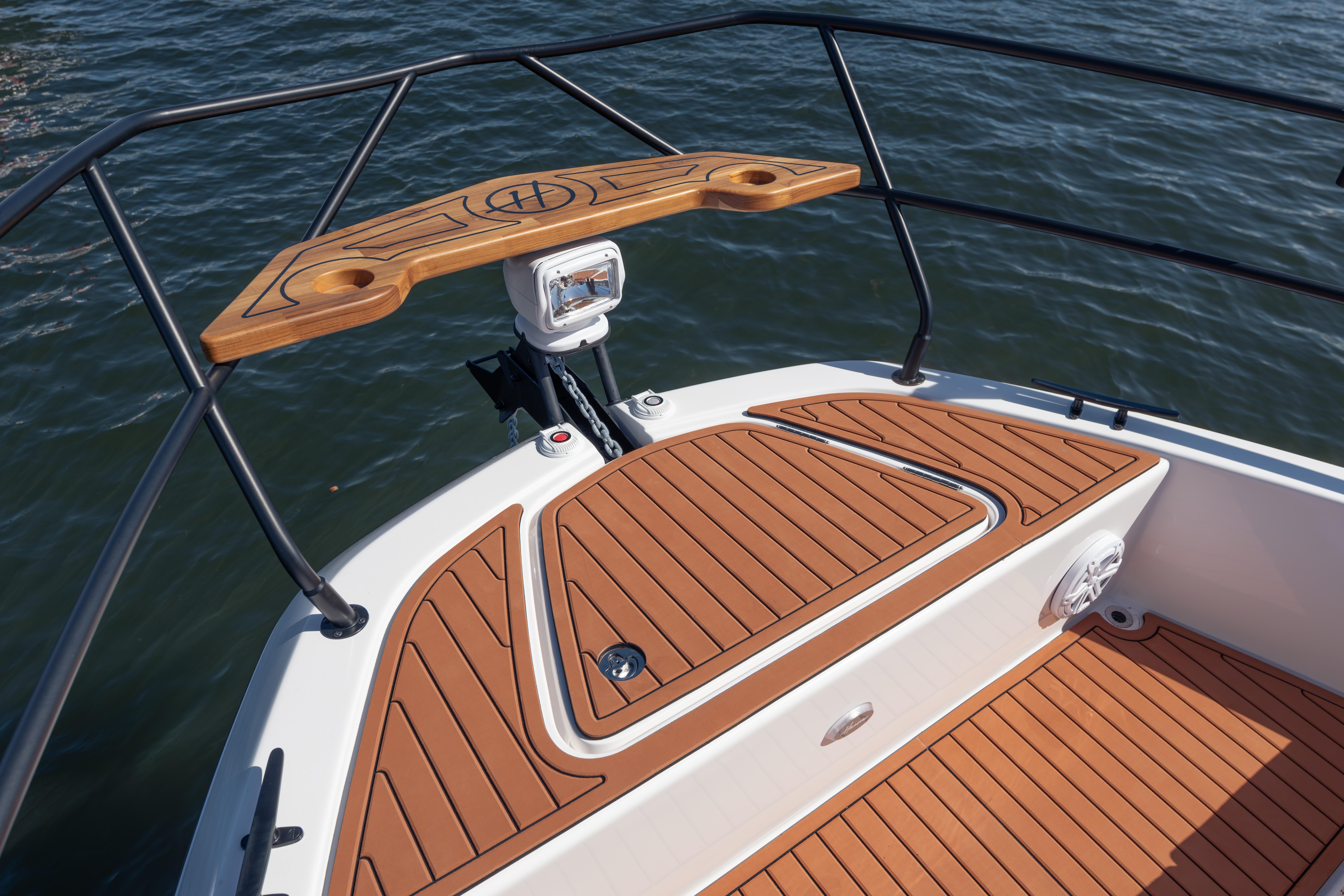 Bow of 2026 Hanover 387 boat with teak decking and railing on water.