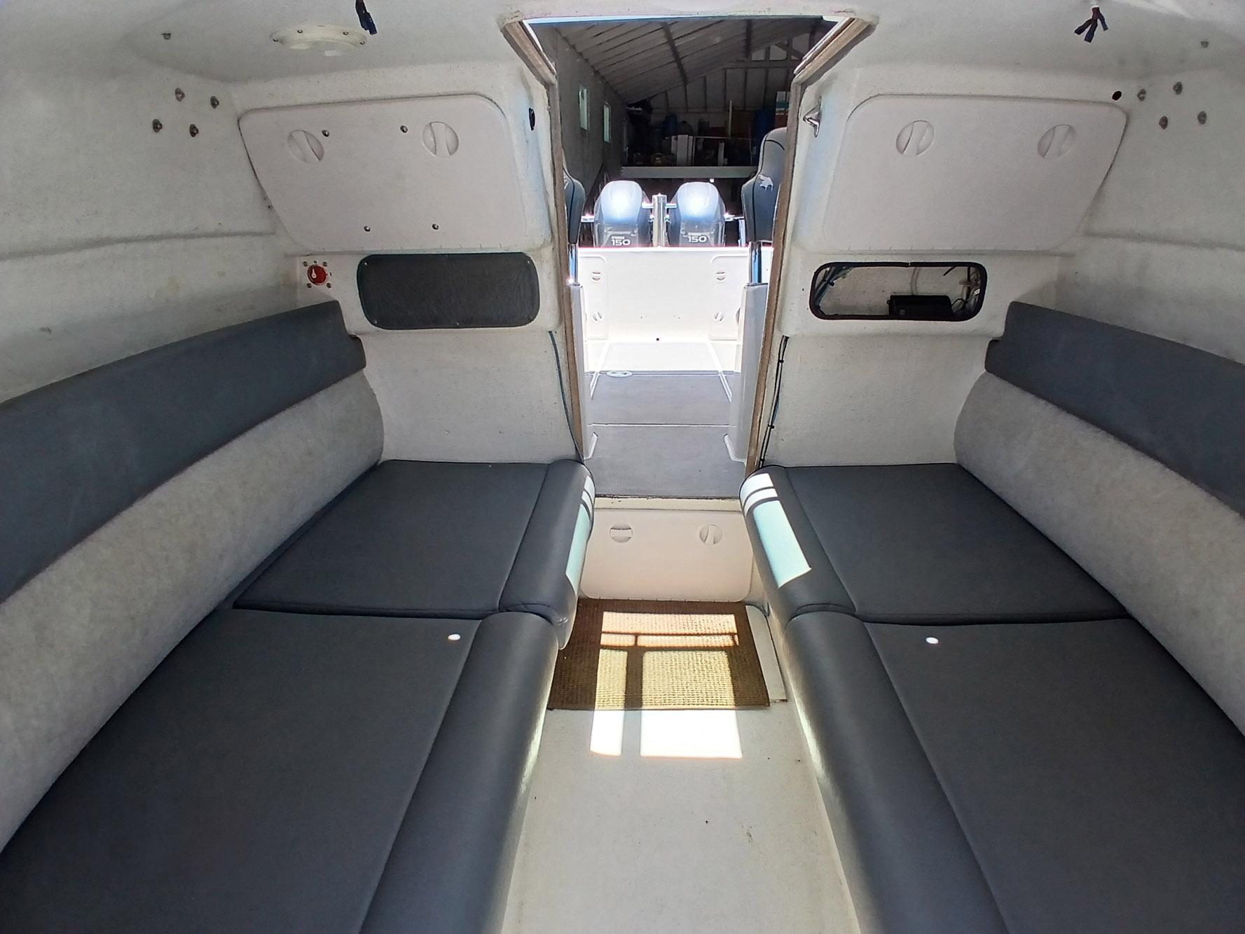 Interior cabin of 2002 Protector 28 Targa boat with seating and open deck view.