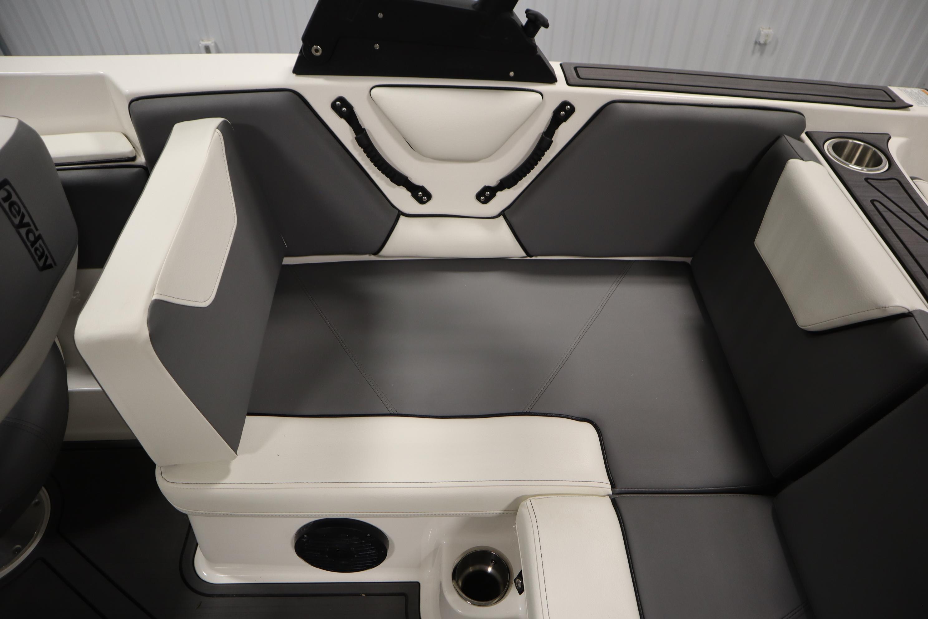 2023 Heyday WT Surf boat interior with gray and white seating, cup holder, and speaker.