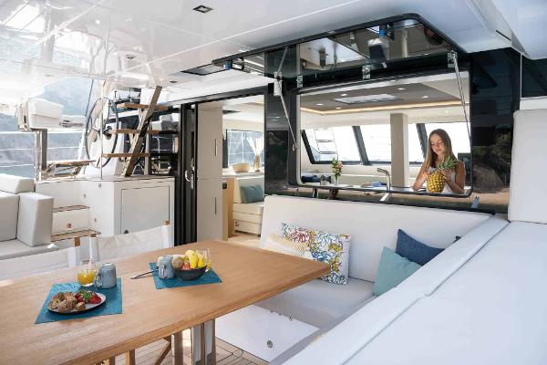 Luxurious interior of 2025 Privilege Signature 580 yacht with dining area and modern decor.