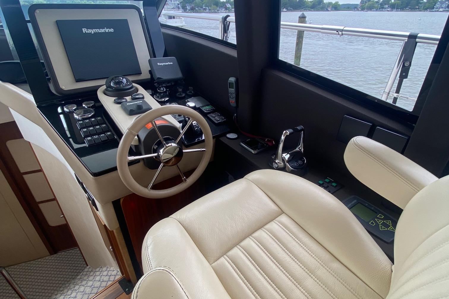 2014 Azimut Magellano 50 yacht helm with Raymarine navigation system and leather seating.