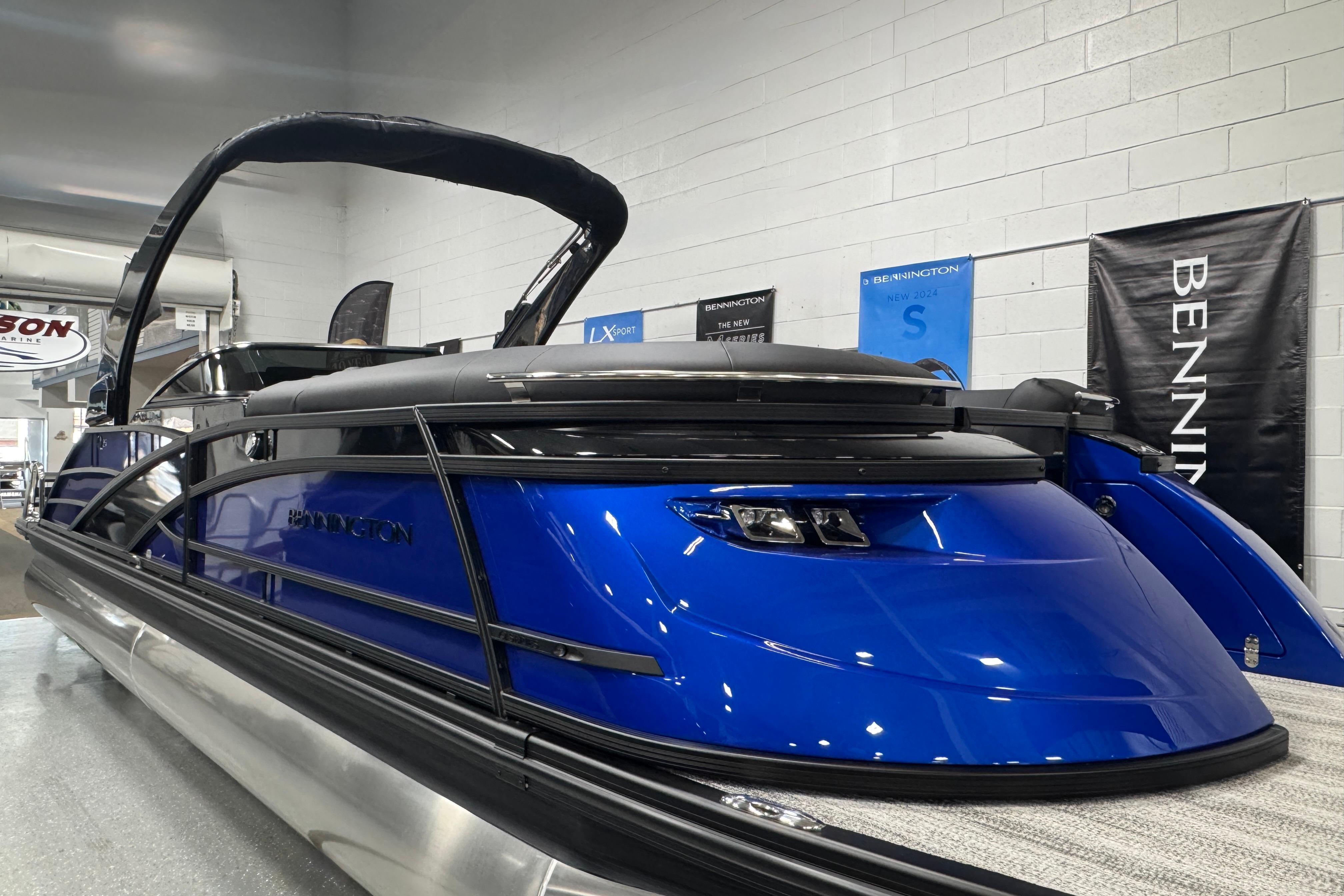 2026 Bennington 25 QSBWASE pontoon boat in showroom, featuring sleek blue design and modern amenities.
