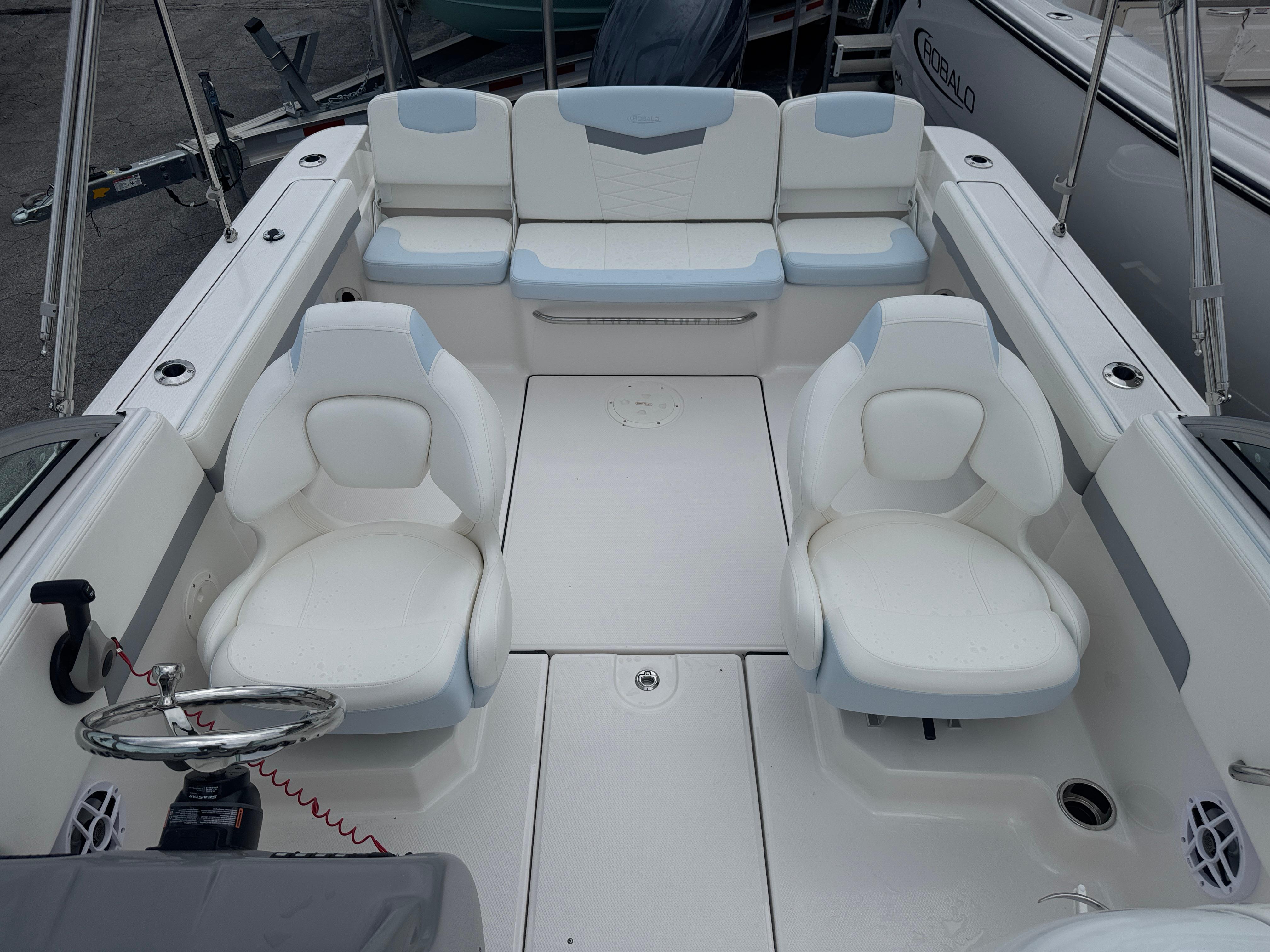 2025 Robalo R207 Dual Console boat interior with white seating and steering wheel.
