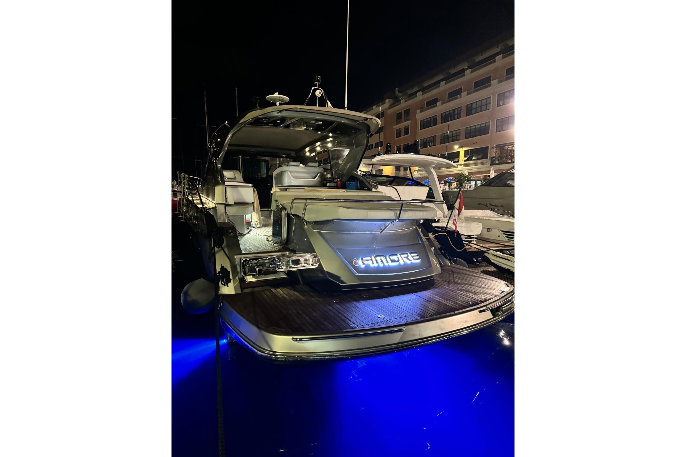 2019 Cranchi M 44 HT yacht docked at night with illuminated nameplate.