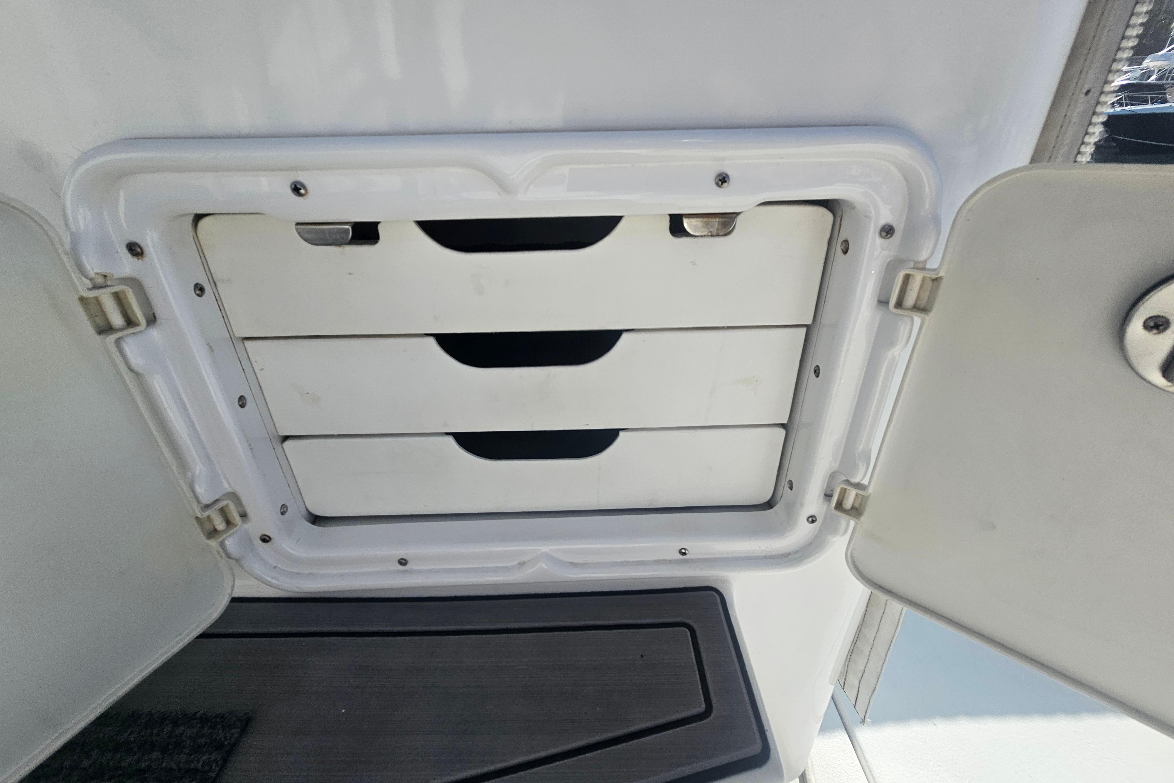 Storage compartment with three drawers on a 2003 Topaz 32 Express boat.