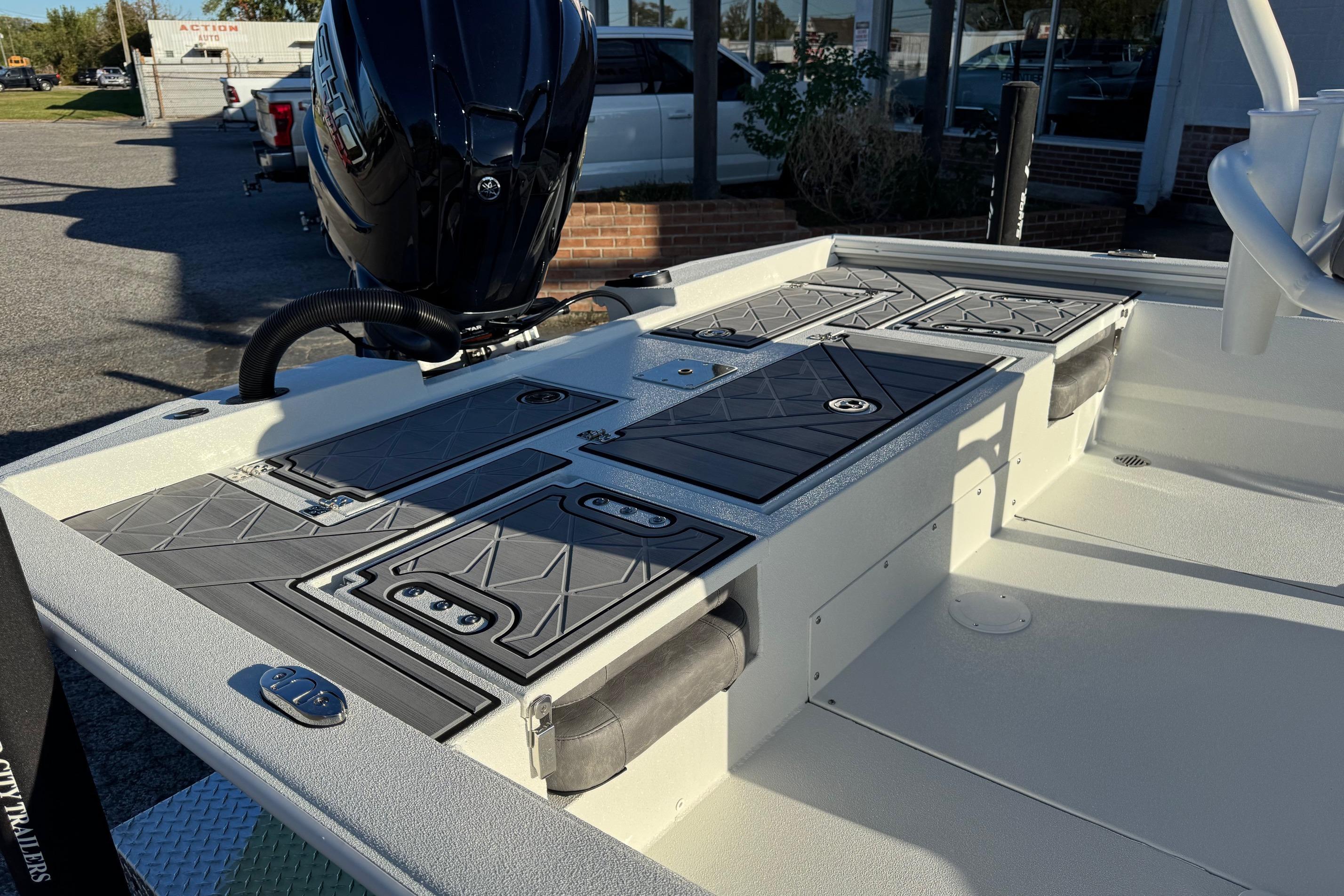 2025 Avid 23 Mag boat deck with storage compartments and outboard motor.