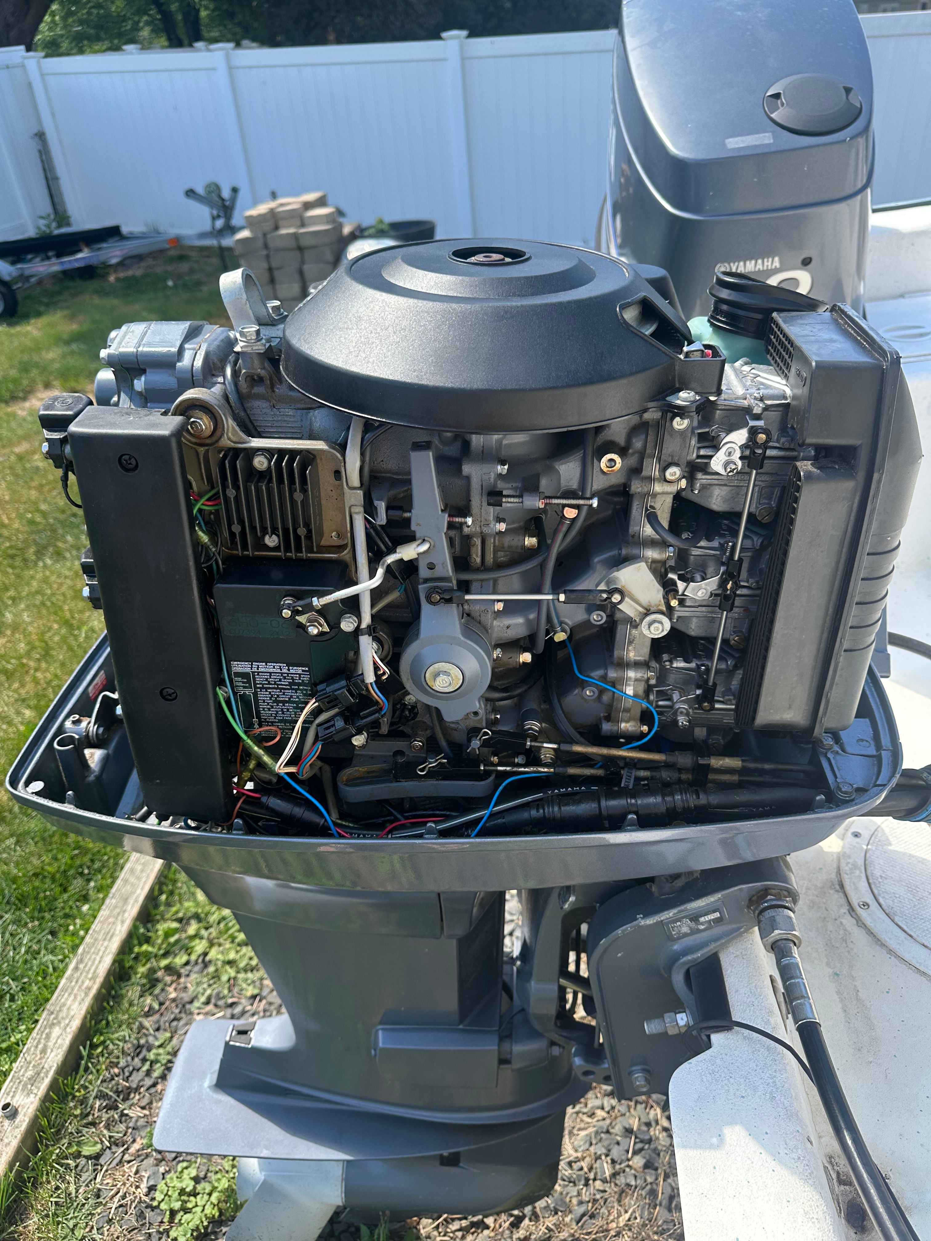 An outboard motor with its cover open, revealing internal components and wiring.