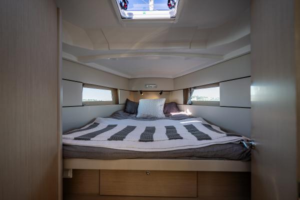 Interior of Beneteau Oceanis 38.1 yacht, cozy cabin with bed.