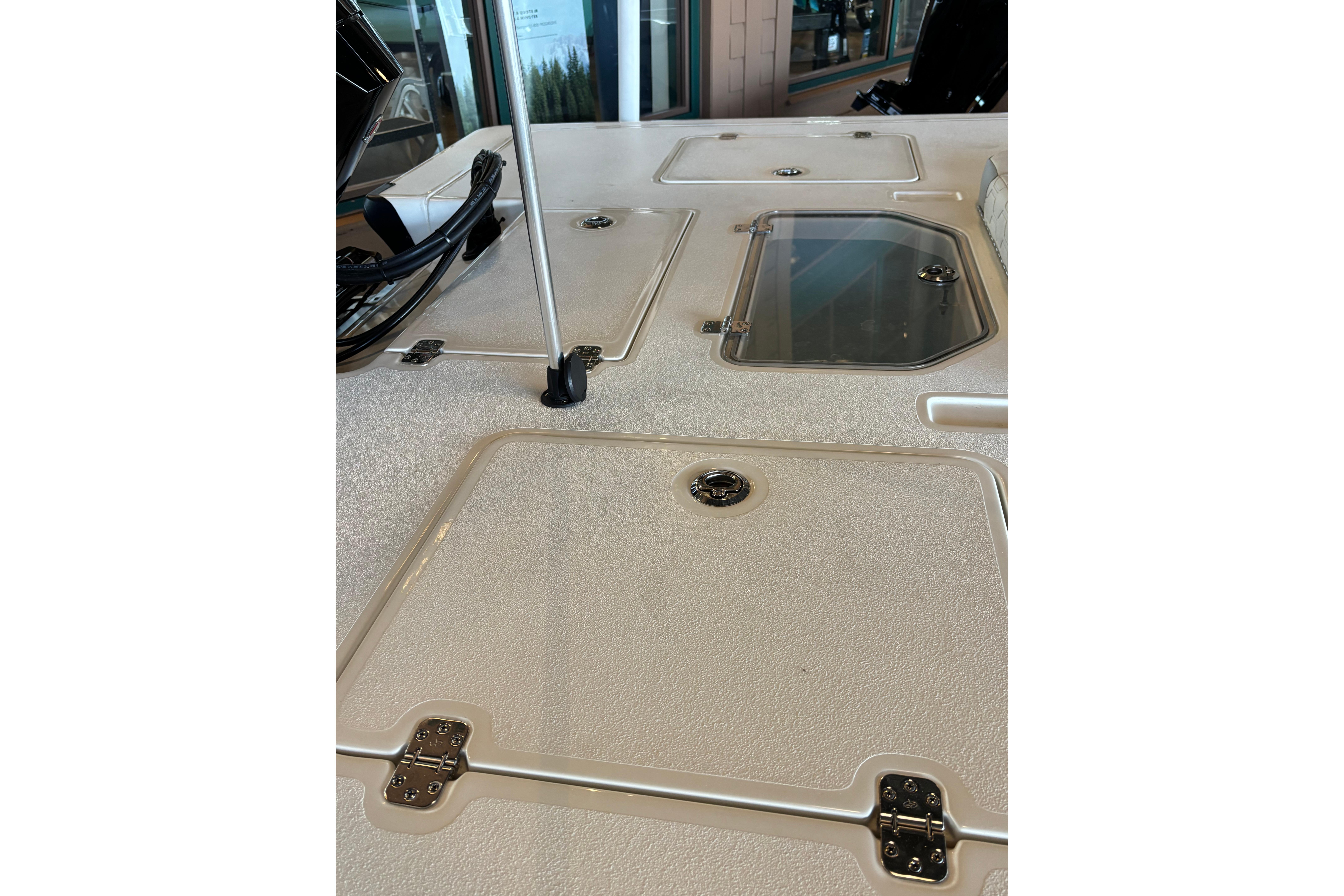 2026 Mako 18 Pro Skiff deck with storage compartments and fishing rod holder.