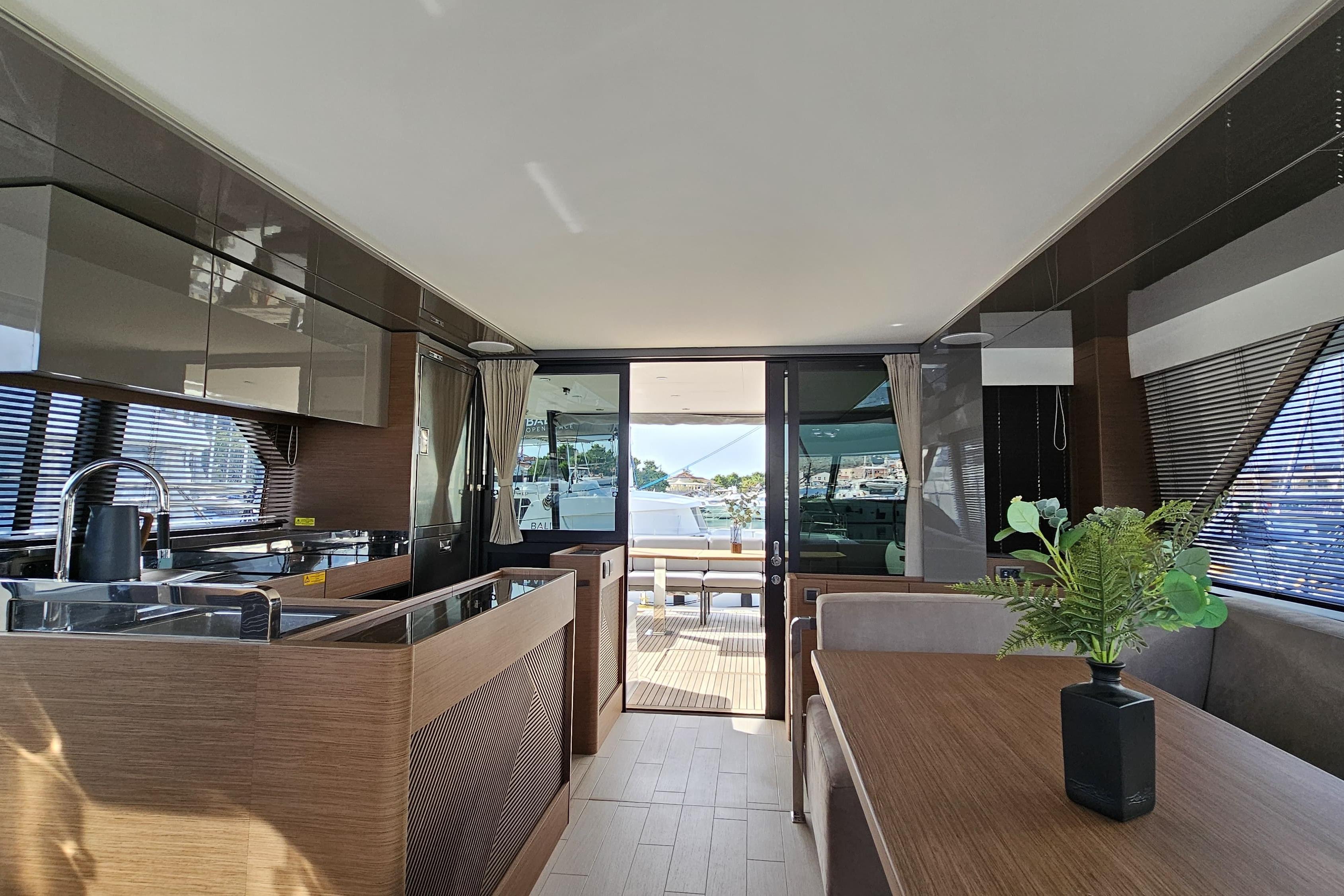 Luxurious interior of 2024 Prestige M48 yacht with modern kitchen and dining area.
