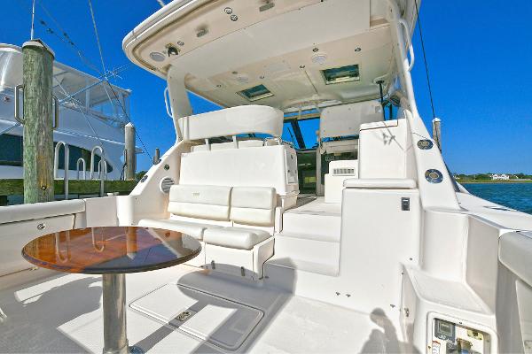 2008 Tiara Yachts 4200 Open cockpit with seating and table, docked under clear blue sky.