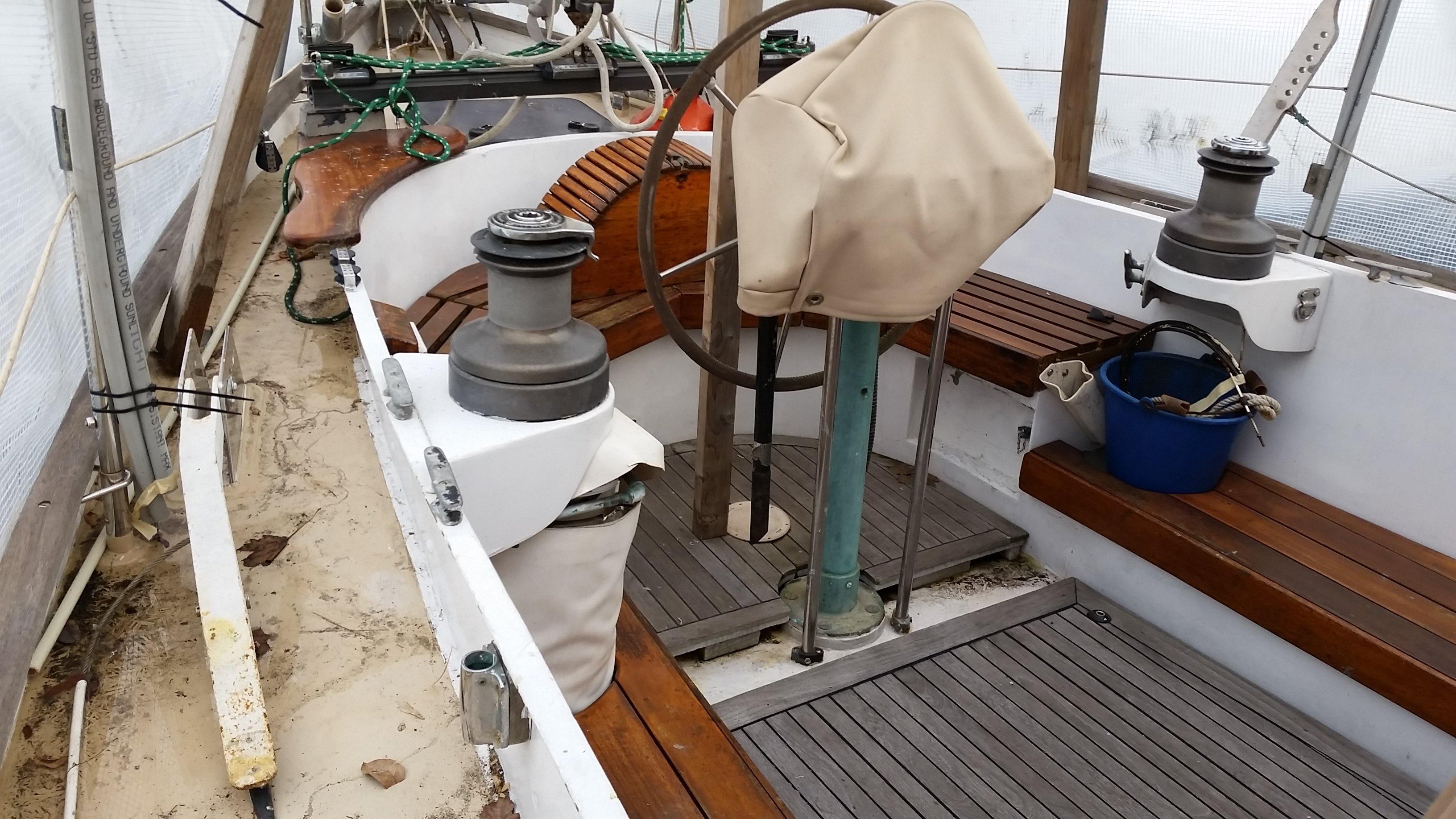 1960 Frans Maas-LeFevre One Off Custom 47 sailboat cockpit with wooden benches and steering wheel.