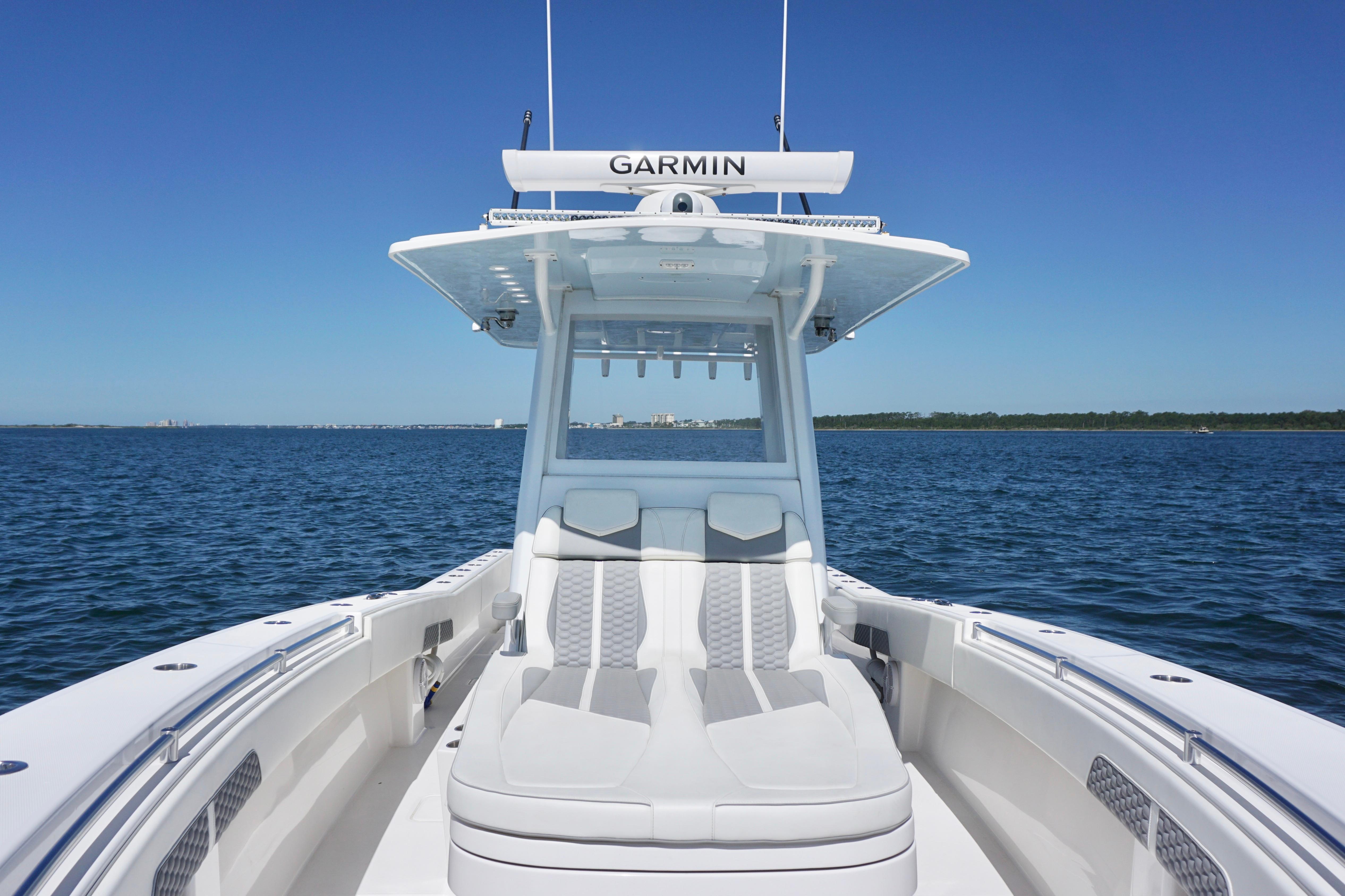2023 Invincible 36 Open Fisherman boat on calm blue water under clear sky.