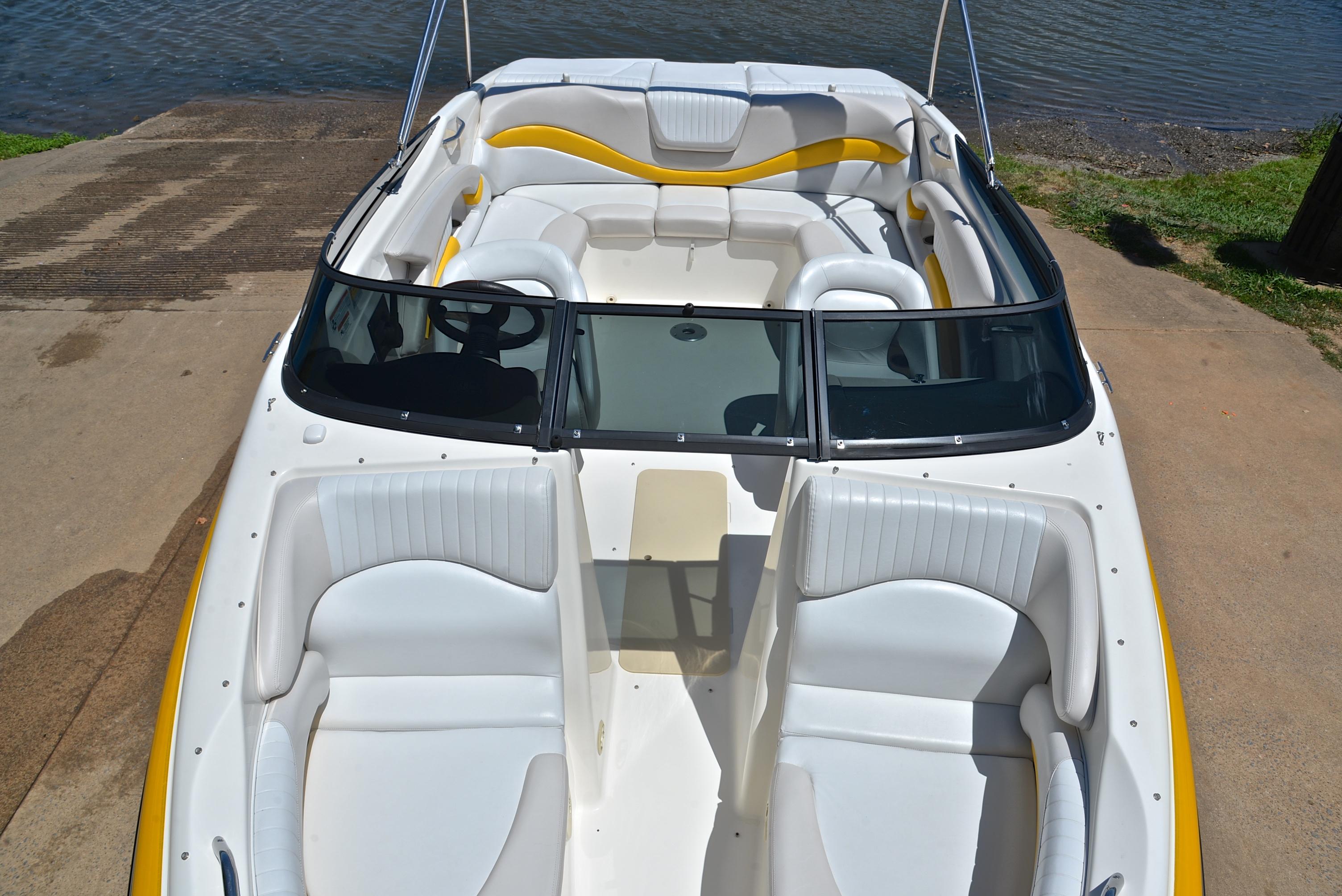 2007 Glastron GXL 235 boat with white and yellow interior, docked near water.