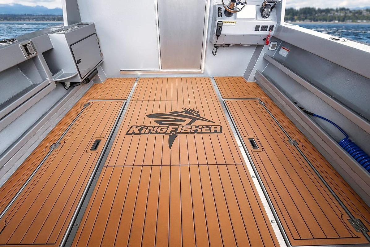 2026 KingFisher 3225 GFX Offshore boat deck with logo, featuring wood-like flooring.