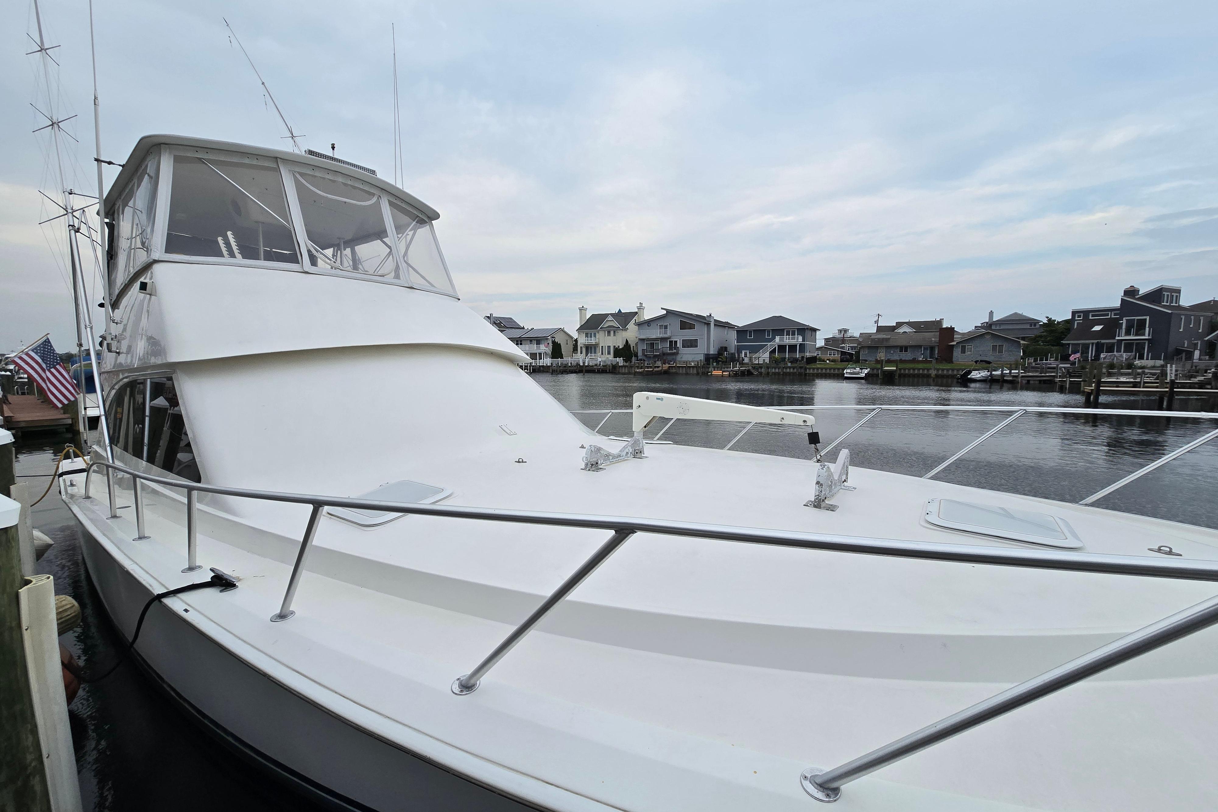 2001 Cavileer 53 Convertible yacht docked in a serene waterfront setting.