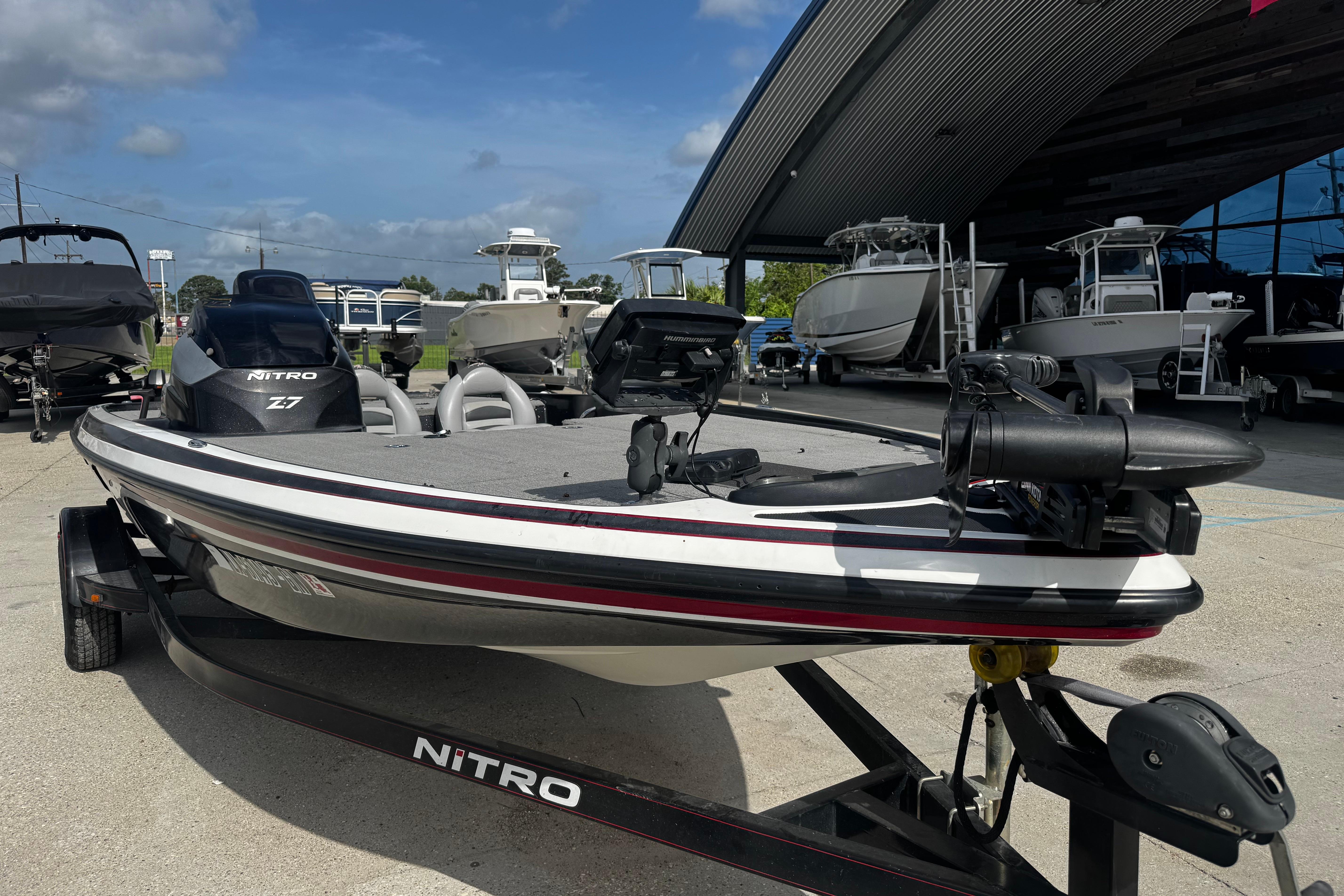 2012 Nitro Z-7 boat on trailer, parked outside a dealership under a clear sky.