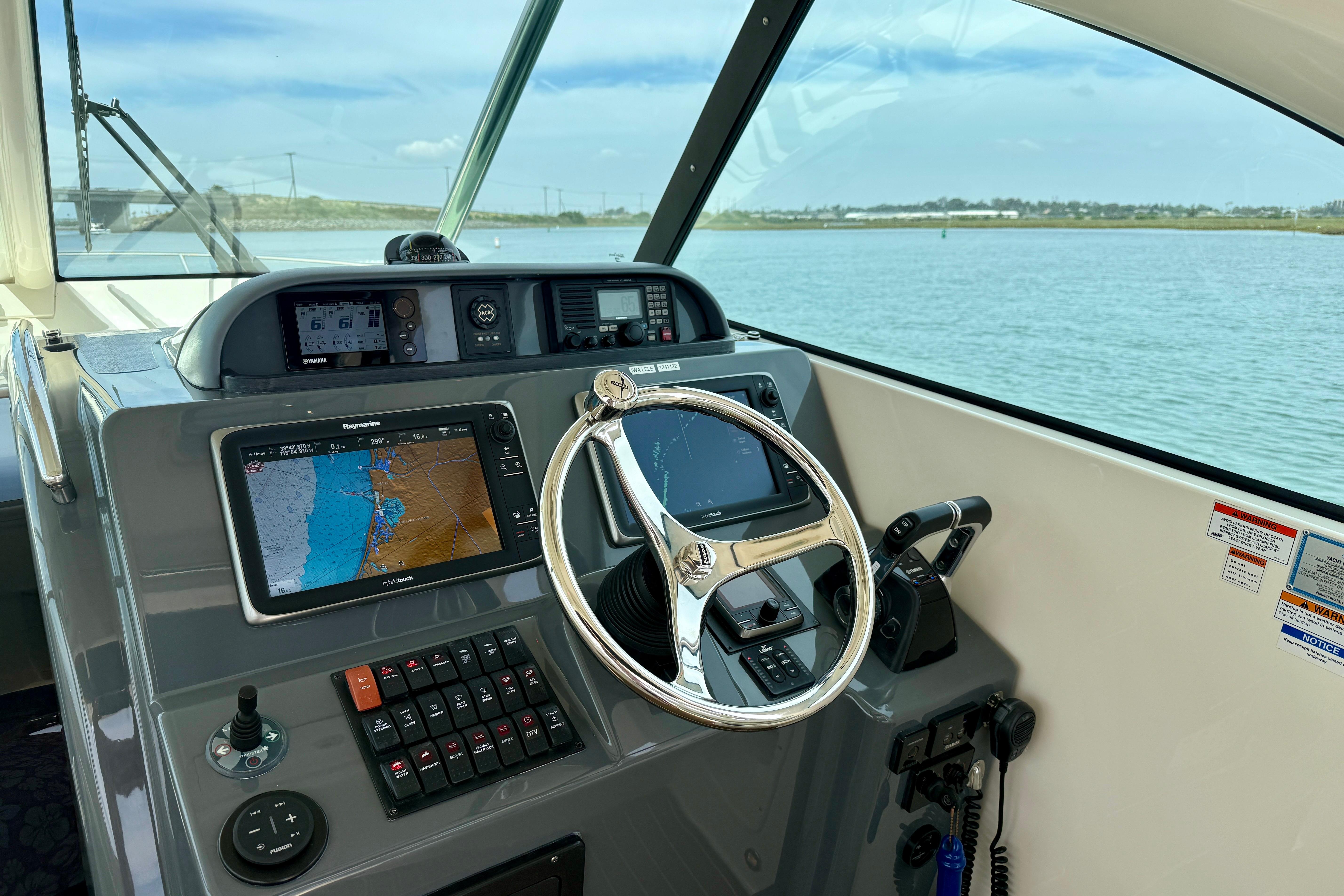 Helm of 2012 Pursuit OS 345 Offshore boat with navigation screens and steering wheel.