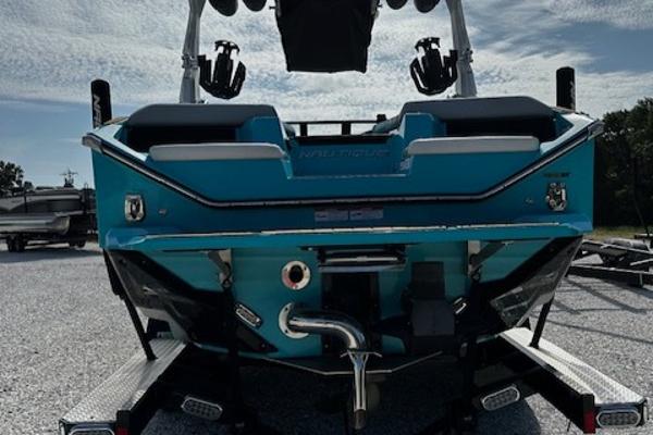 2022 Nautique S23 boat rear view on trailer, showcasing sleek design and vibrant blue color.