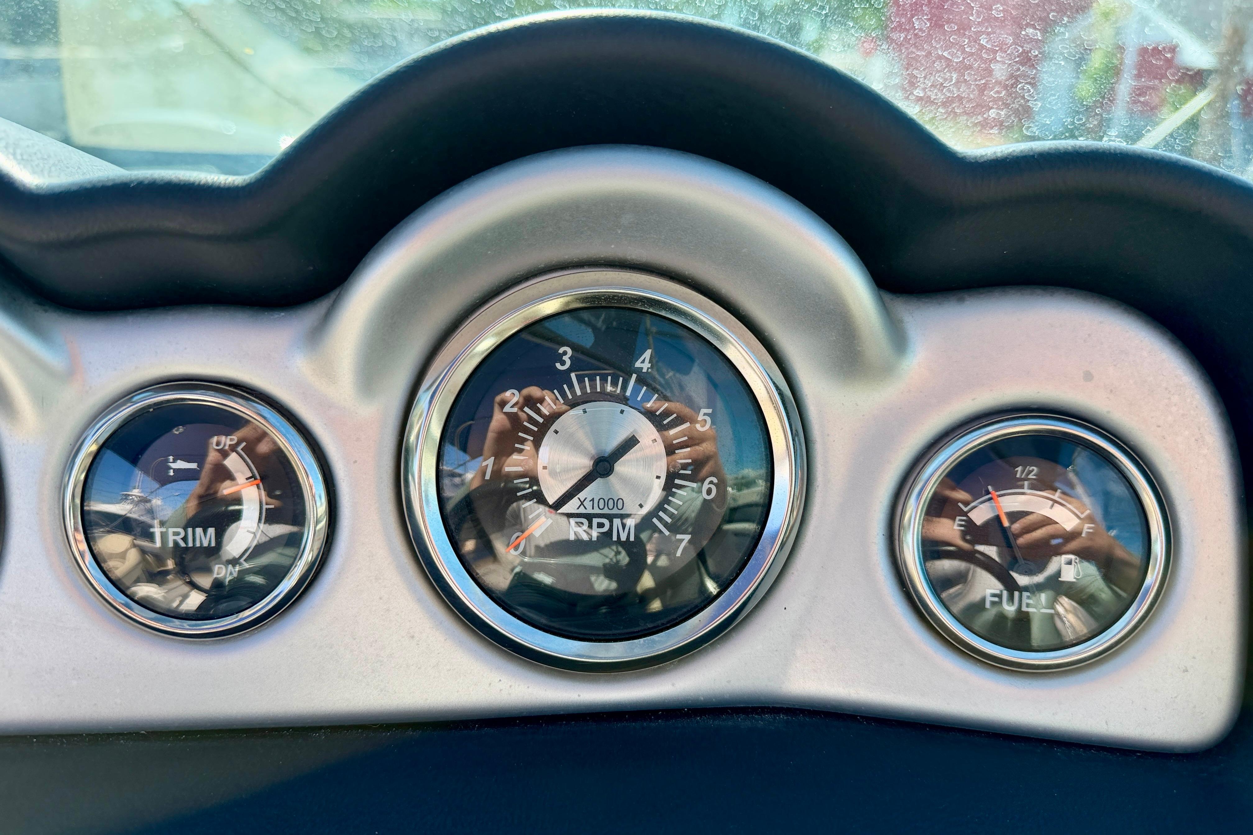 Dashboard gauges of a 2014 NauticStar 243DC Sport Deck boat, showing trim, RPM, and fuel levels.