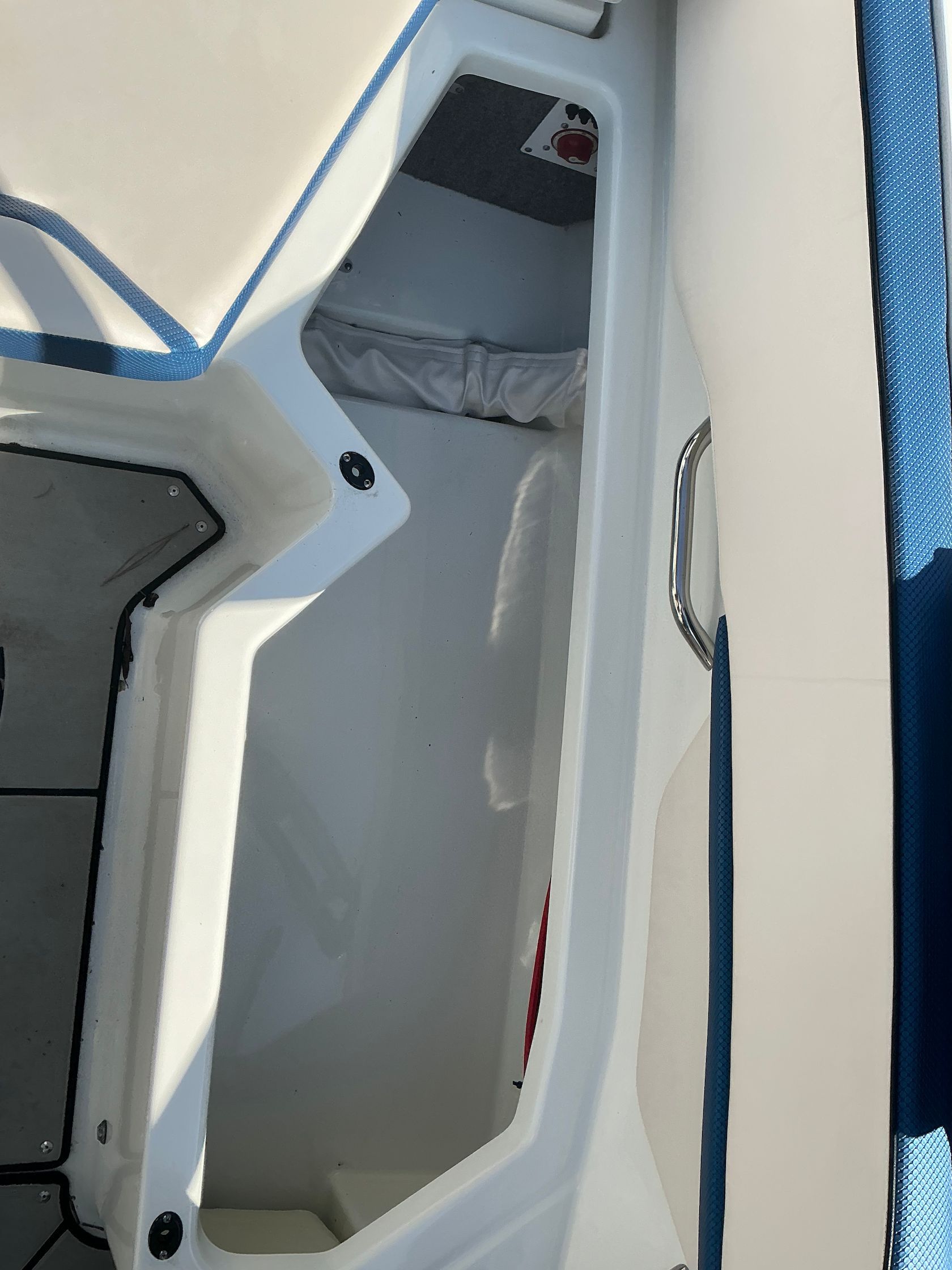 Interior of a 2021 Scarab 215 ID boat with storage compartment.