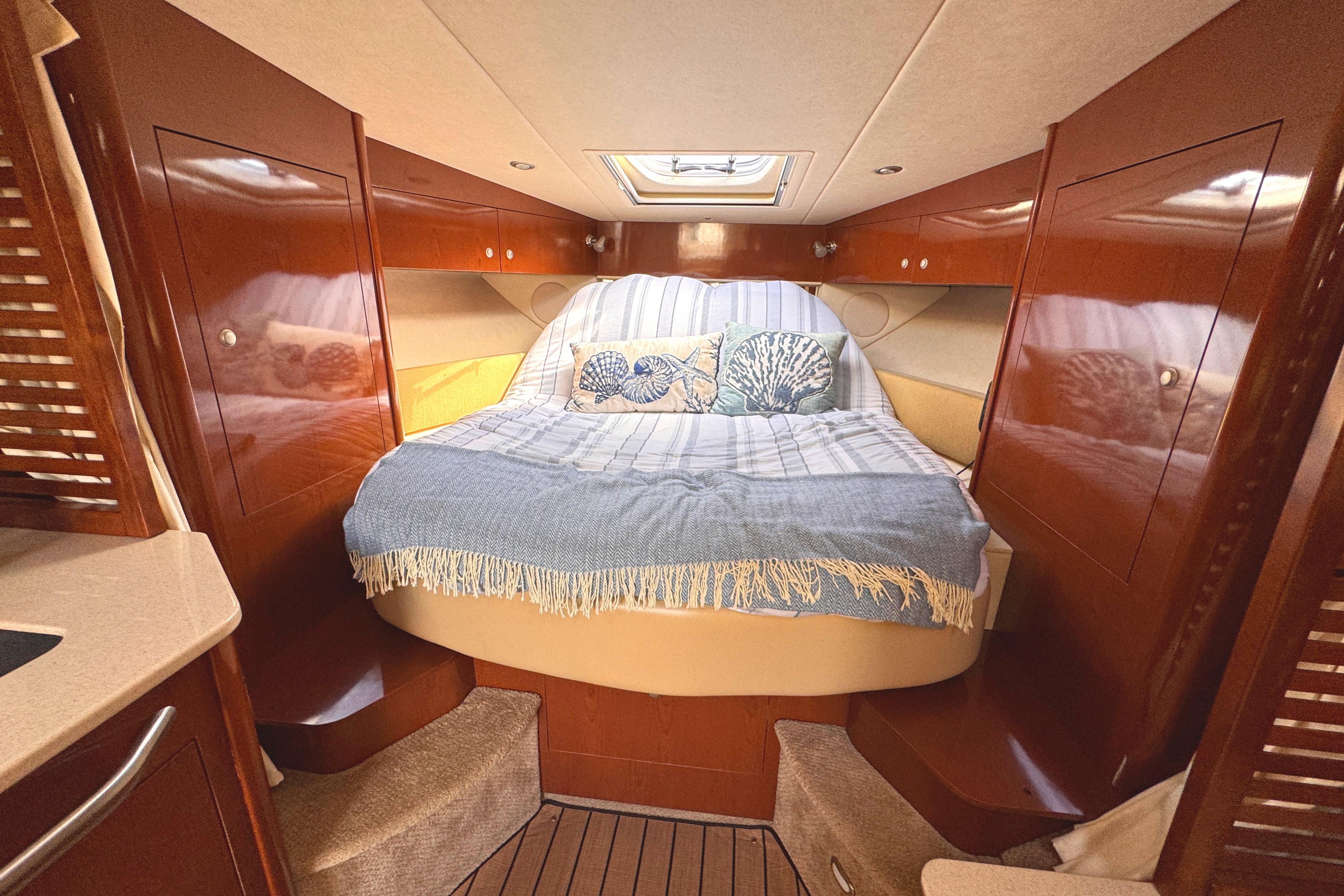 Luxurious cabin interior of 2008 Sea Ray Sundancer 350 yacht with cozy bedding.