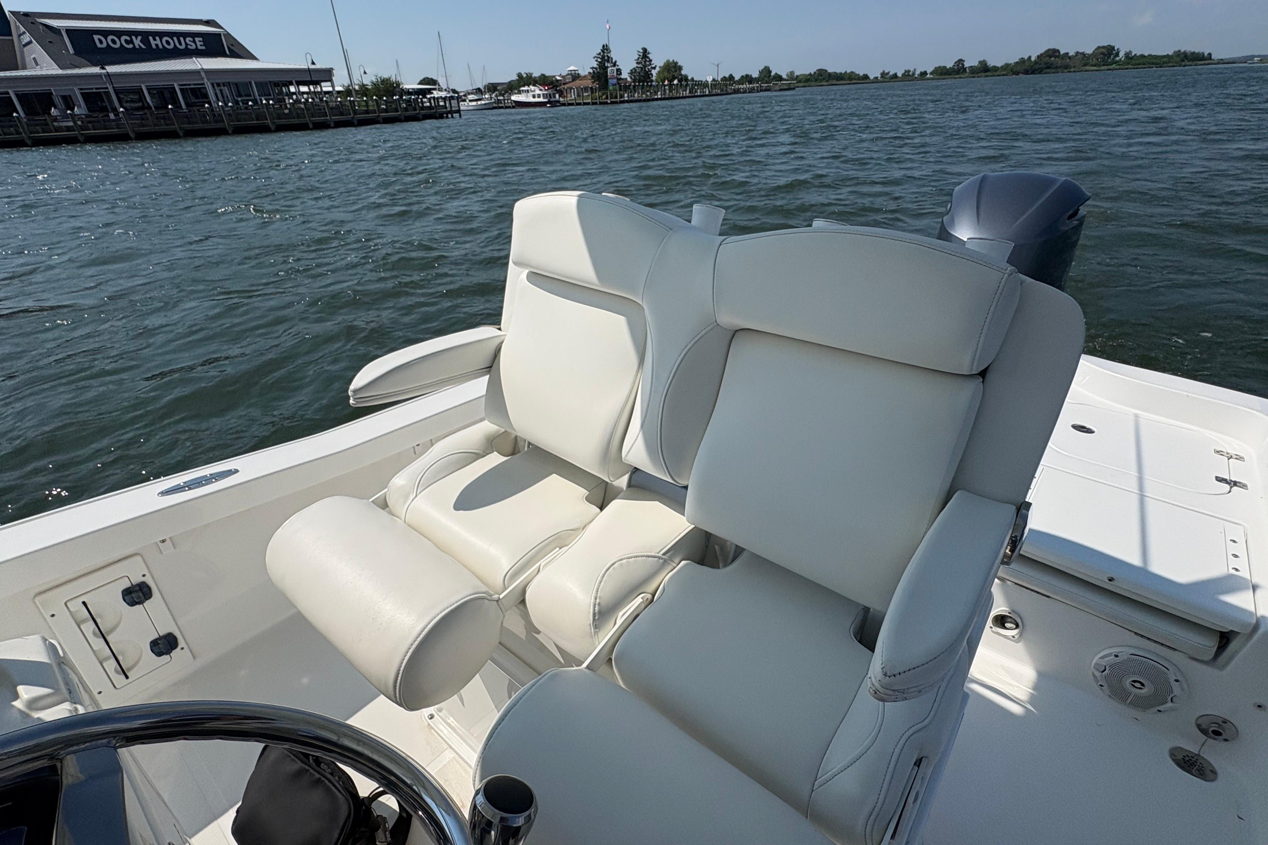 2017 Sea Hunt BX 25 BR boat with white seating, dock house in background.