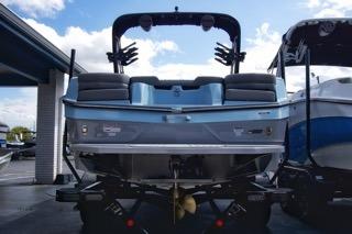 2025 MasterCraft XT22 T boat, rear view, parked at a marina.