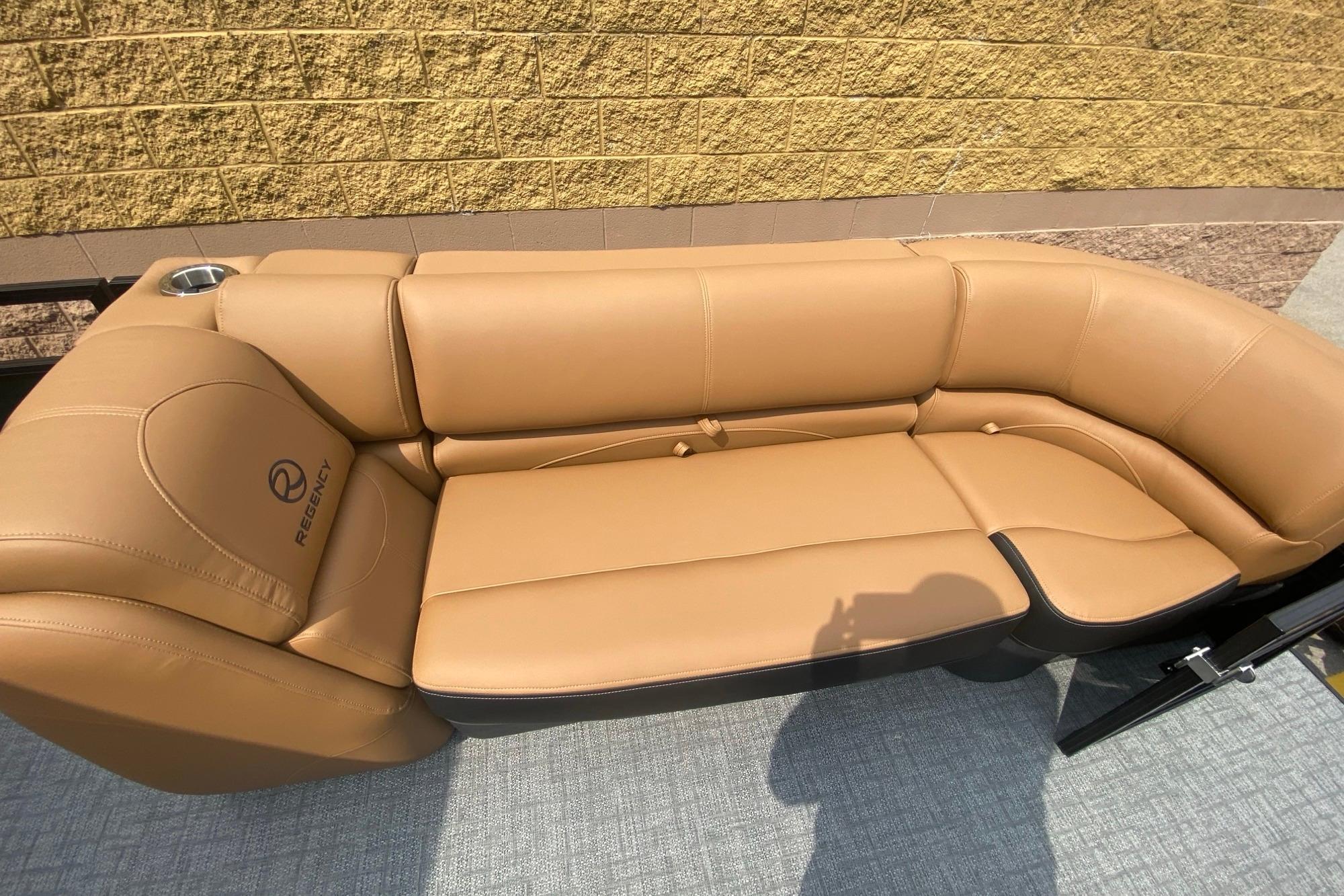 Luxurious tan seating on 2026 Regency 230 DL boat, featuring cup holder and elegant design.
