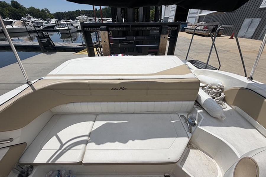 2018 Sea Ray SPX 190 boat interior with beige seating at a marina.