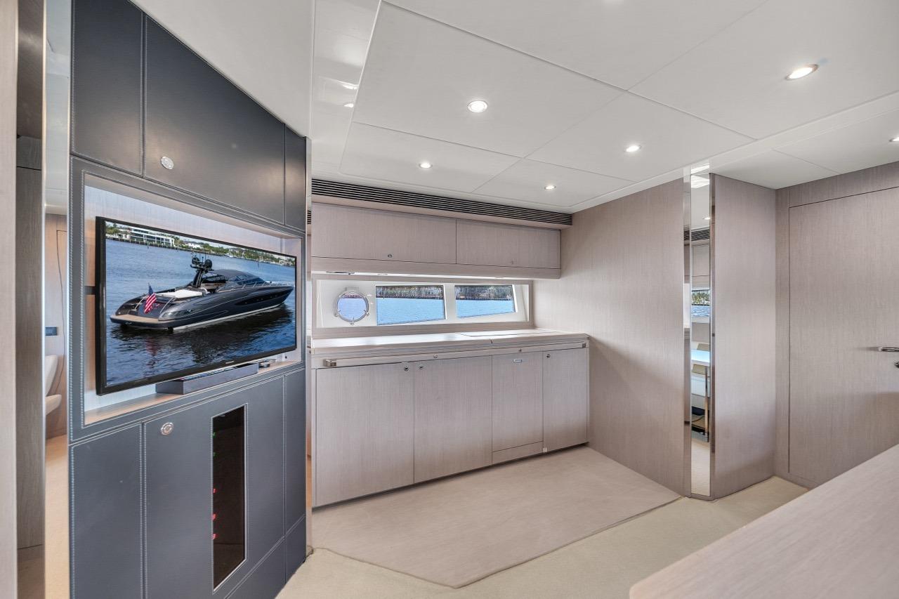 Luxurious interior of 2015 Riva 63 yacht with modern design and large TV display.
