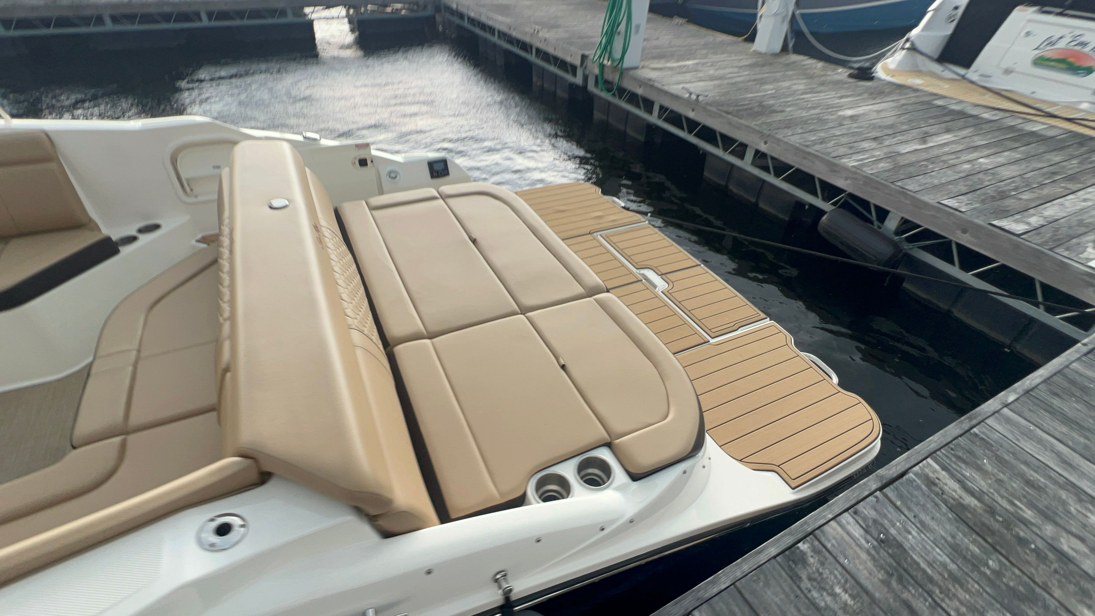 2018 Sea Ray SDX 270 boat at dock with sunbathing area.