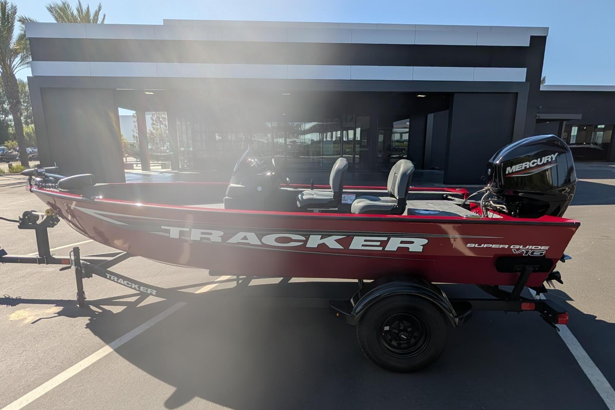 2026 Tracker Super Guide V-16 SC boat with Mercury engine, parked outdoors.