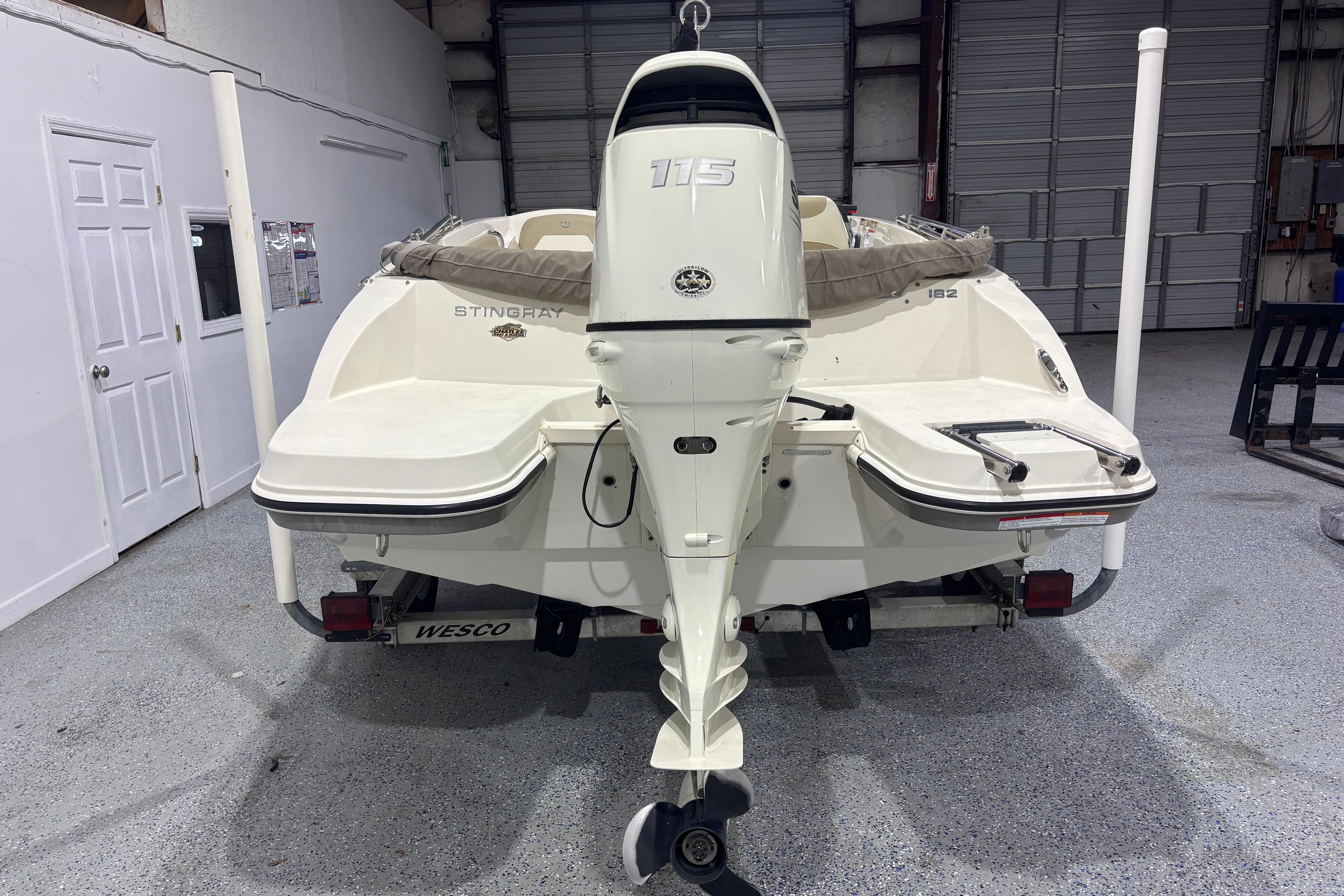 2017 Stingray 182 SC boat with outboard motor in a garage setting.