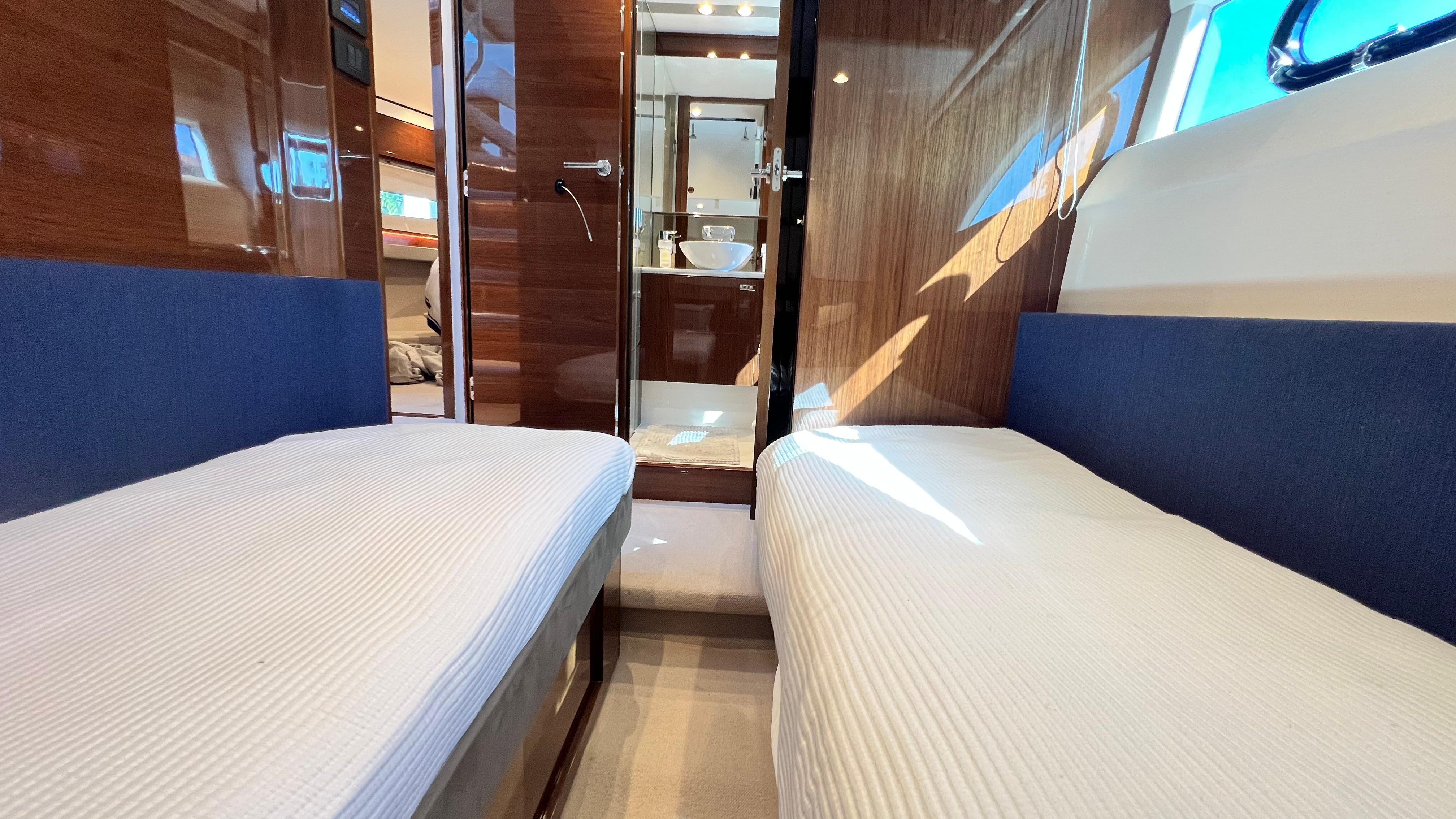 Luxurious 2019 Princess F62 yacht interior with twin beds and modern bathroom.