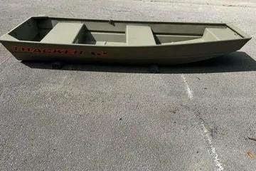 2026 Tracker Grizzly 12 Jon boat on pavement, olive green color.