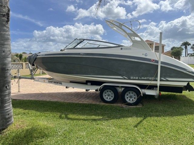 2015 Yamaha 242 Limited S boat parked on trailer outdoors.