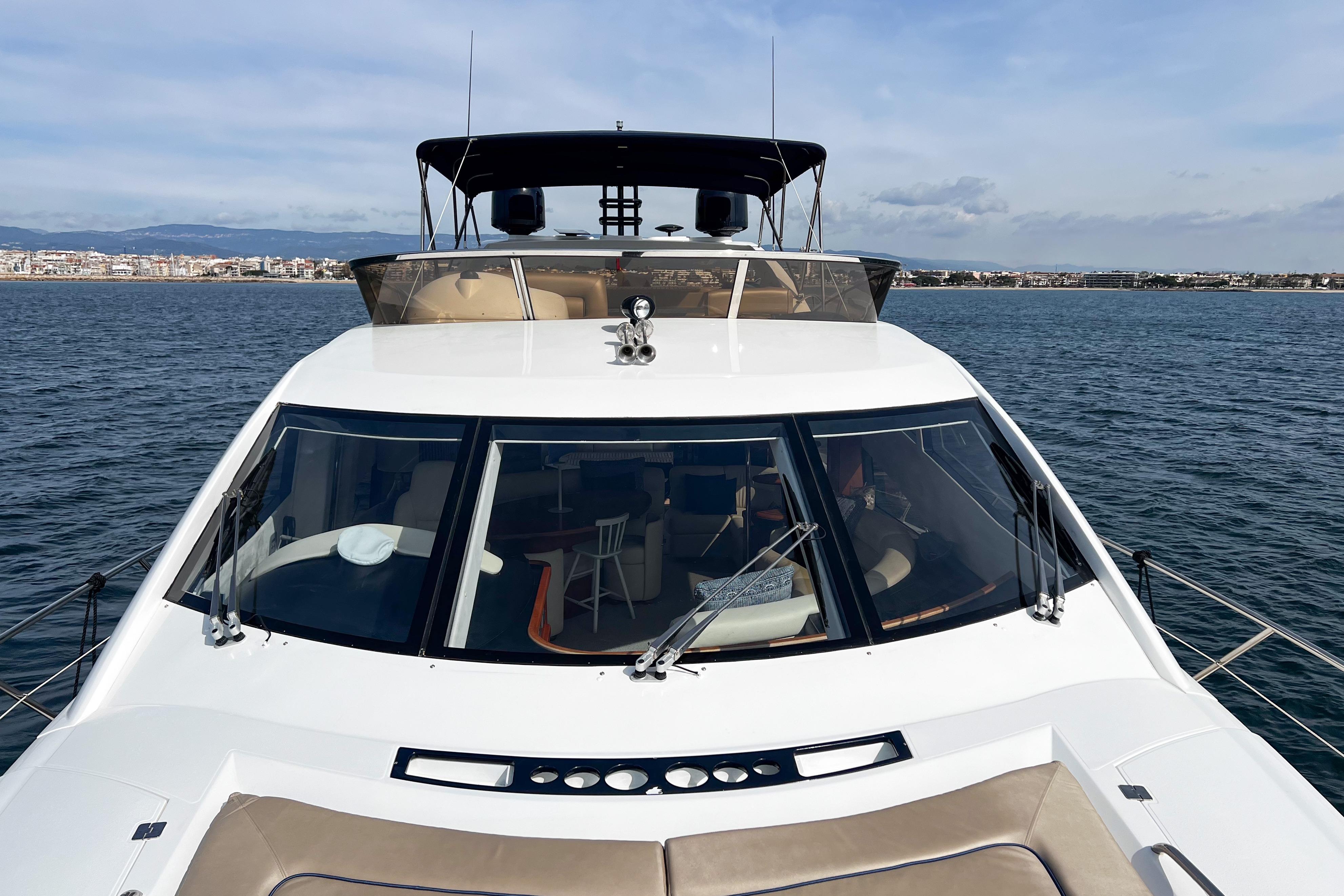 2007 Sunseeker Manhattan 66 yacht on calm waters, cityscape in background.