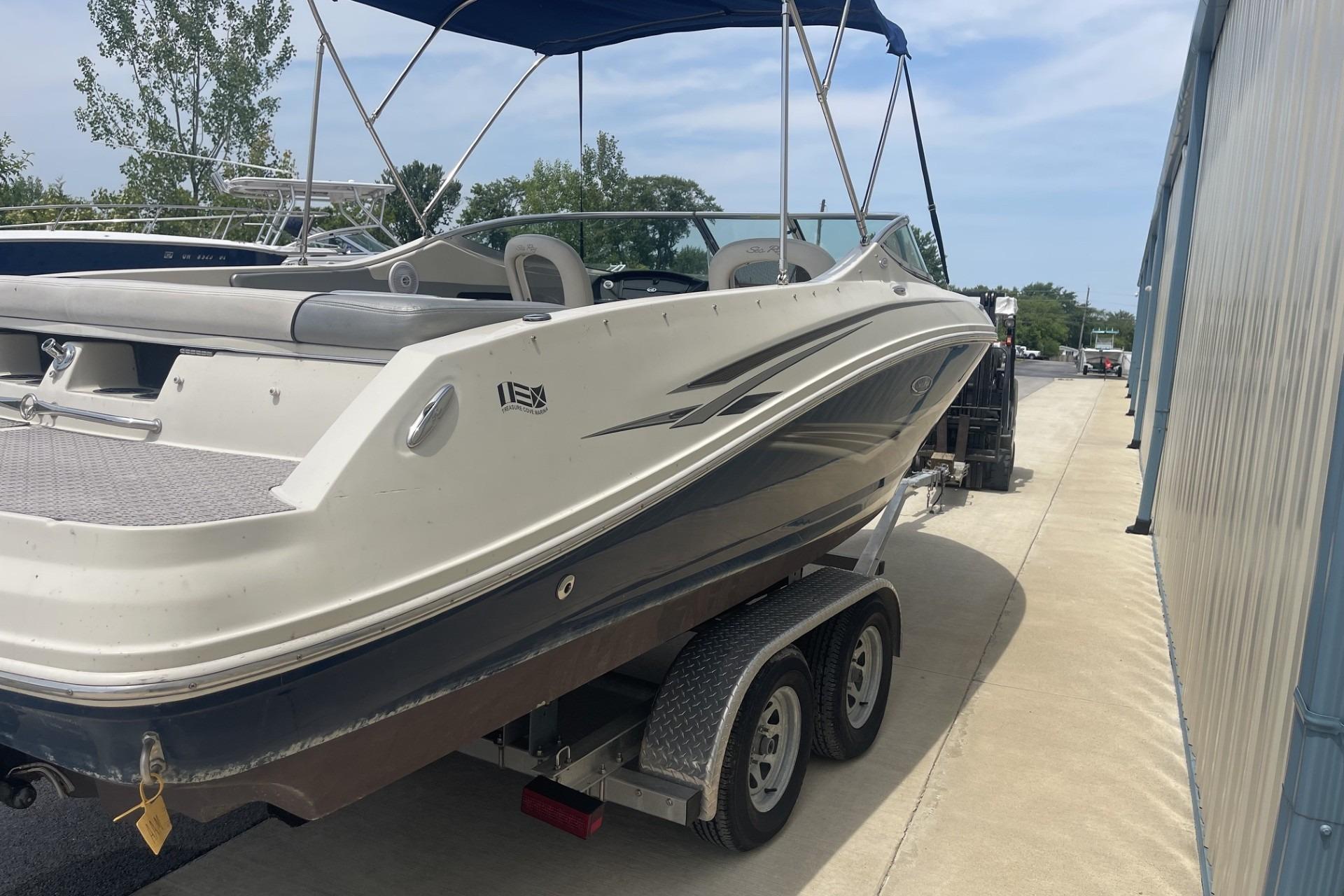 2010 Sea Ray 230 Bow Rider Select on trailer, parked outdoors near a building.