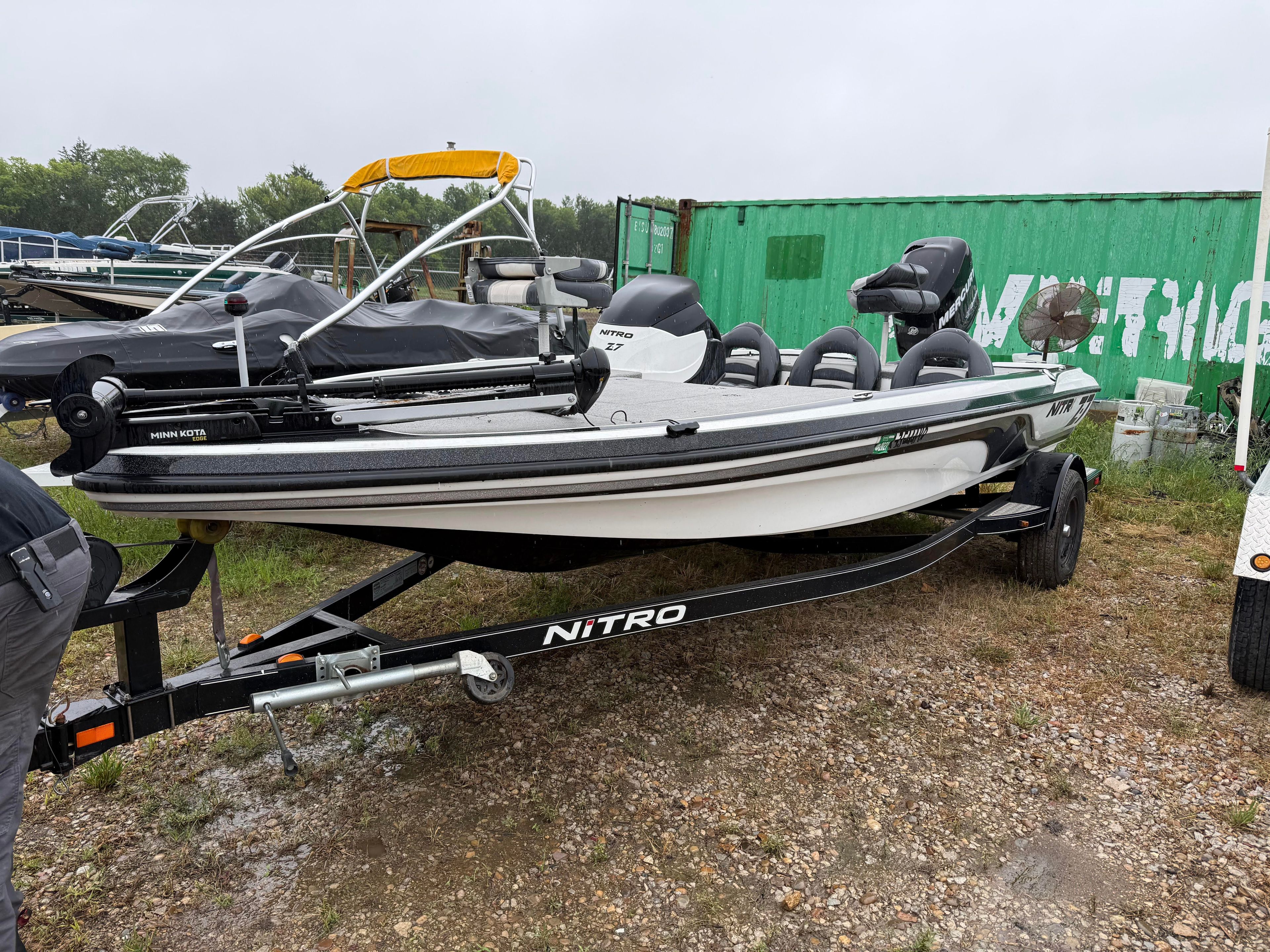 A 2011 Nitro Z-7 boat on a trailer, surrounded by other boats and containers.