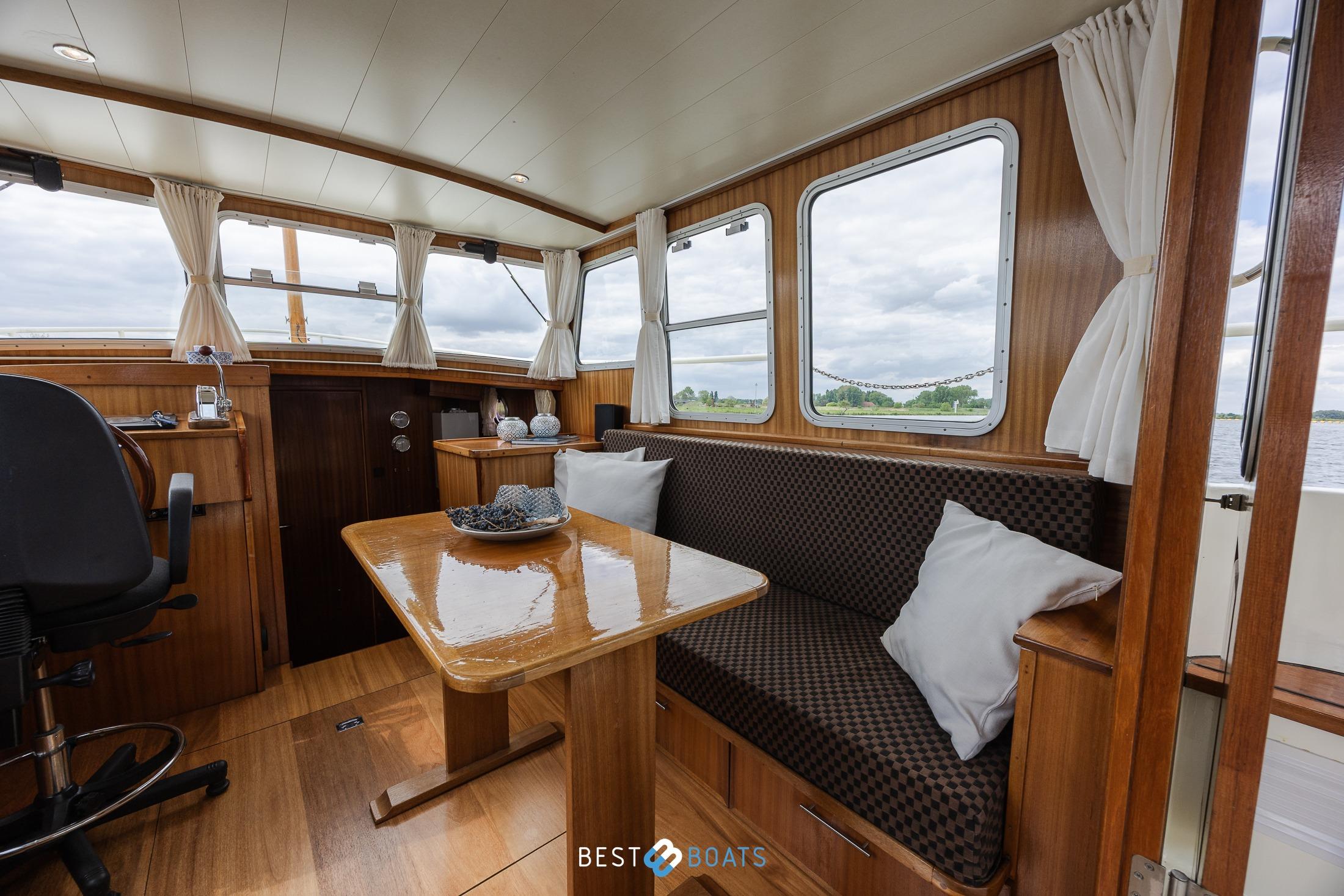 Interior of 2004 Vripack 965 OK boat with wooden furnishings and large windows.