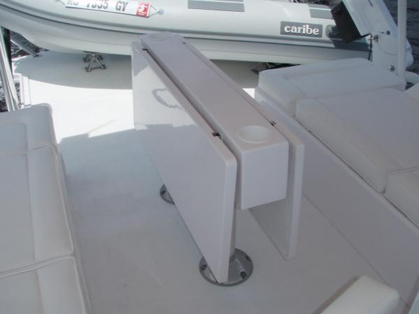 Foldable table on 2025 Great Harbour N40 yacht deck, with seating and inflatable boat nearby.