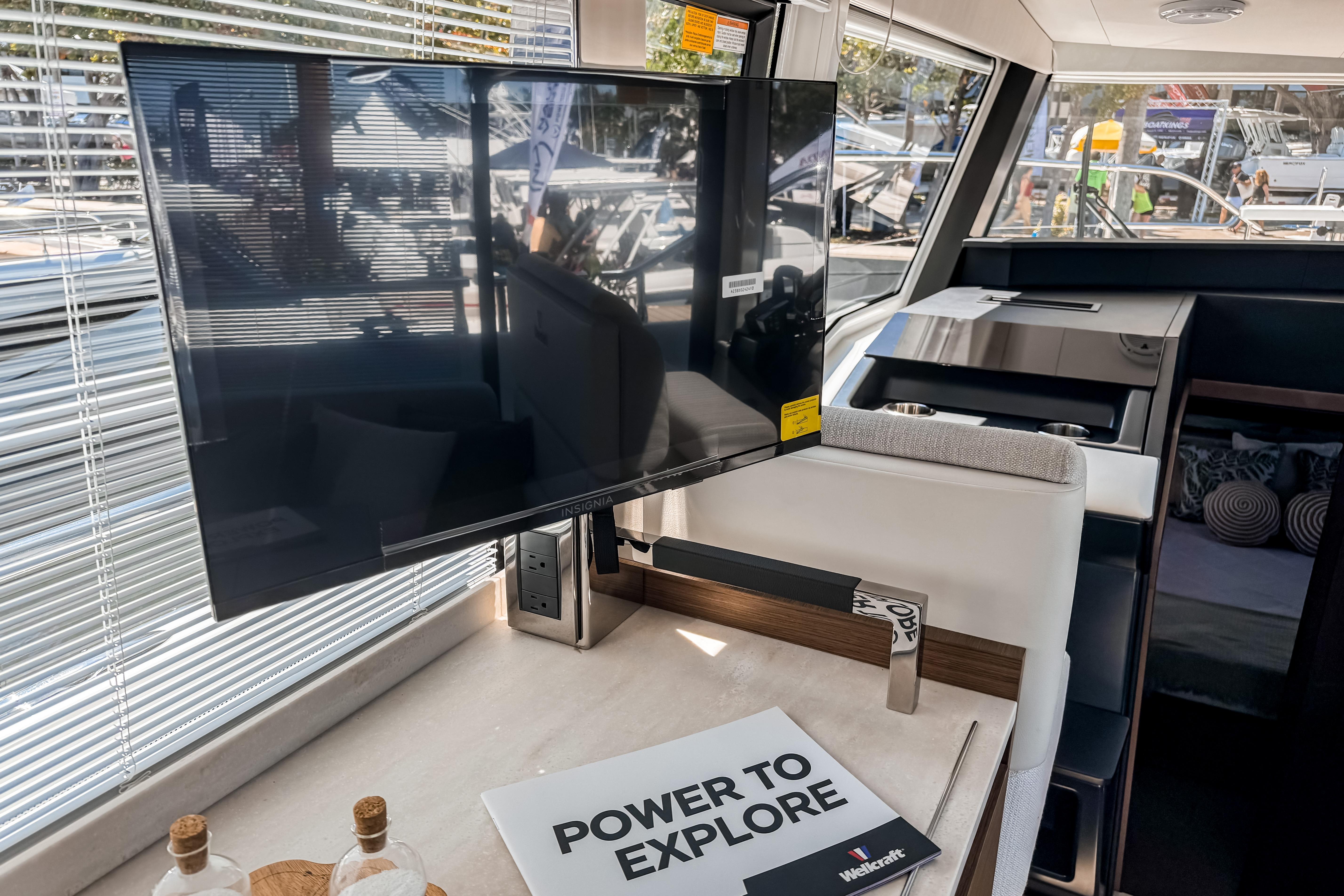 Interior of 2026 Wellcraft 44 Explorer with TV and brochure.