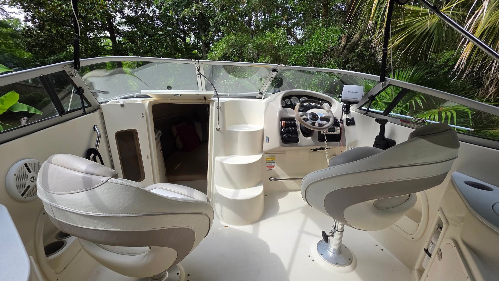 The image shows the cockpit of a 2006 Stingray 250 CR boat with two seats and a helm.