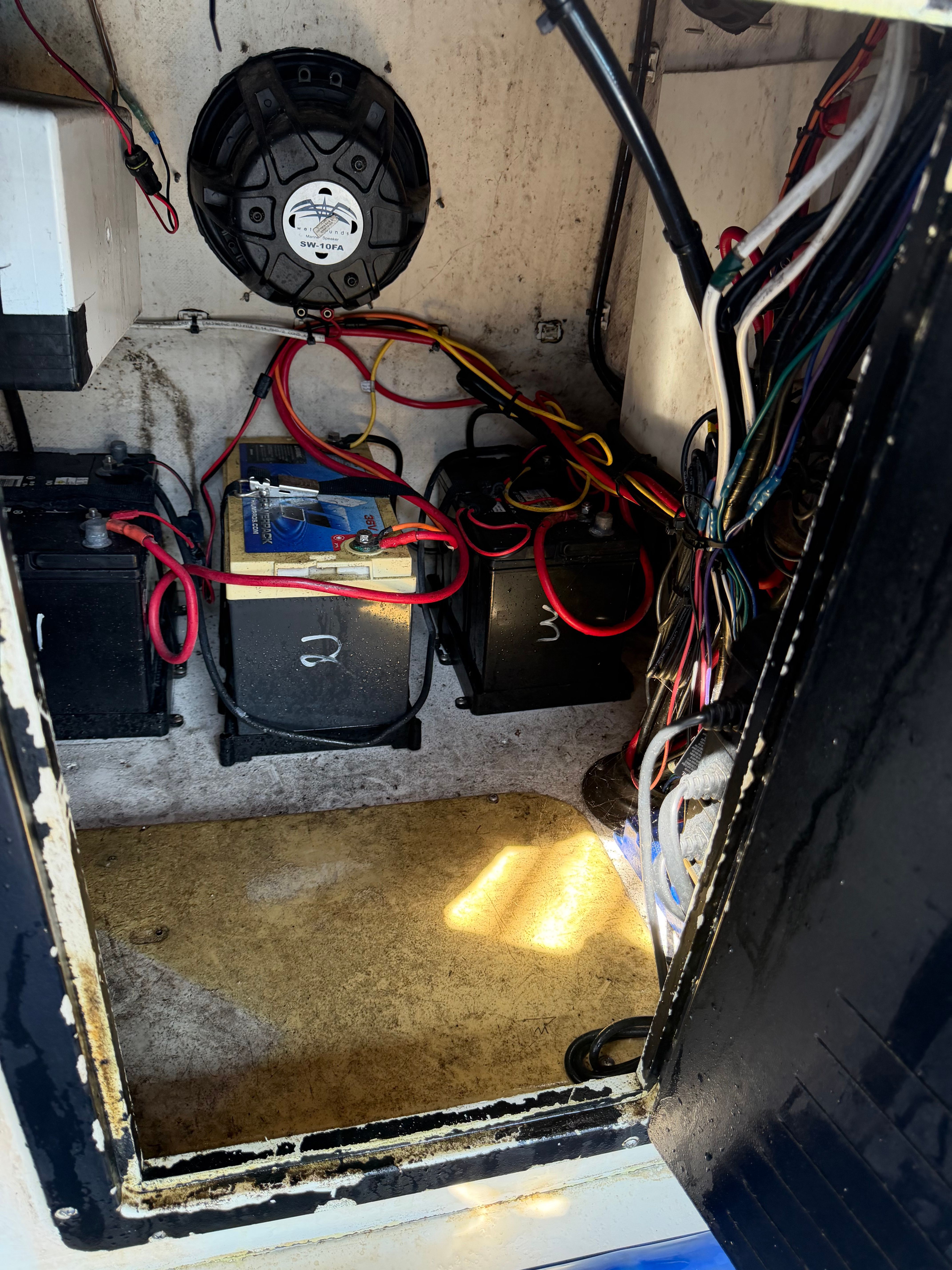 A boat's engine compartment with batteries and wiring.
