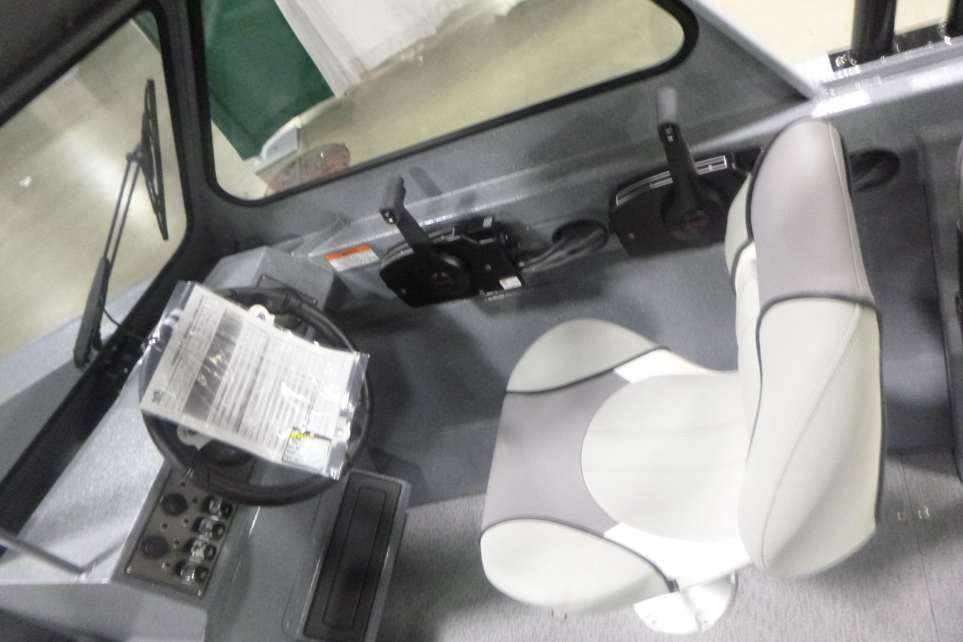 Interior of 2026 KingFisher 2025 Falcon boat with steering wheel and seat.